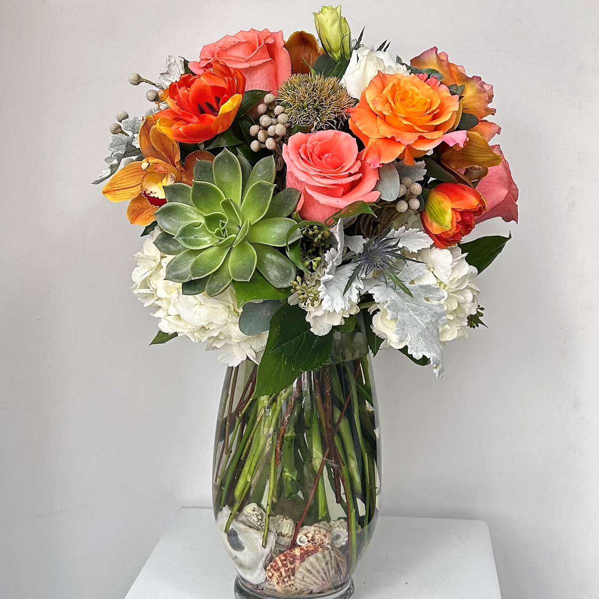 Mixed bouquet in a glass vase with succulents and roses