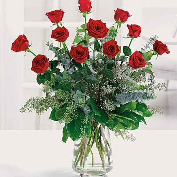 Red roses arranged in a clear glass vase