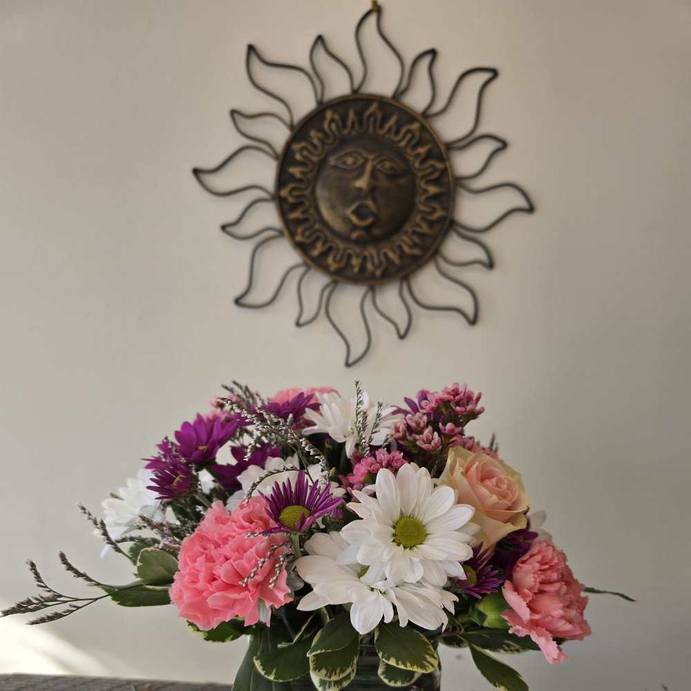 Mixed bouquet in a square glass vase with pink, white, and purple flowers