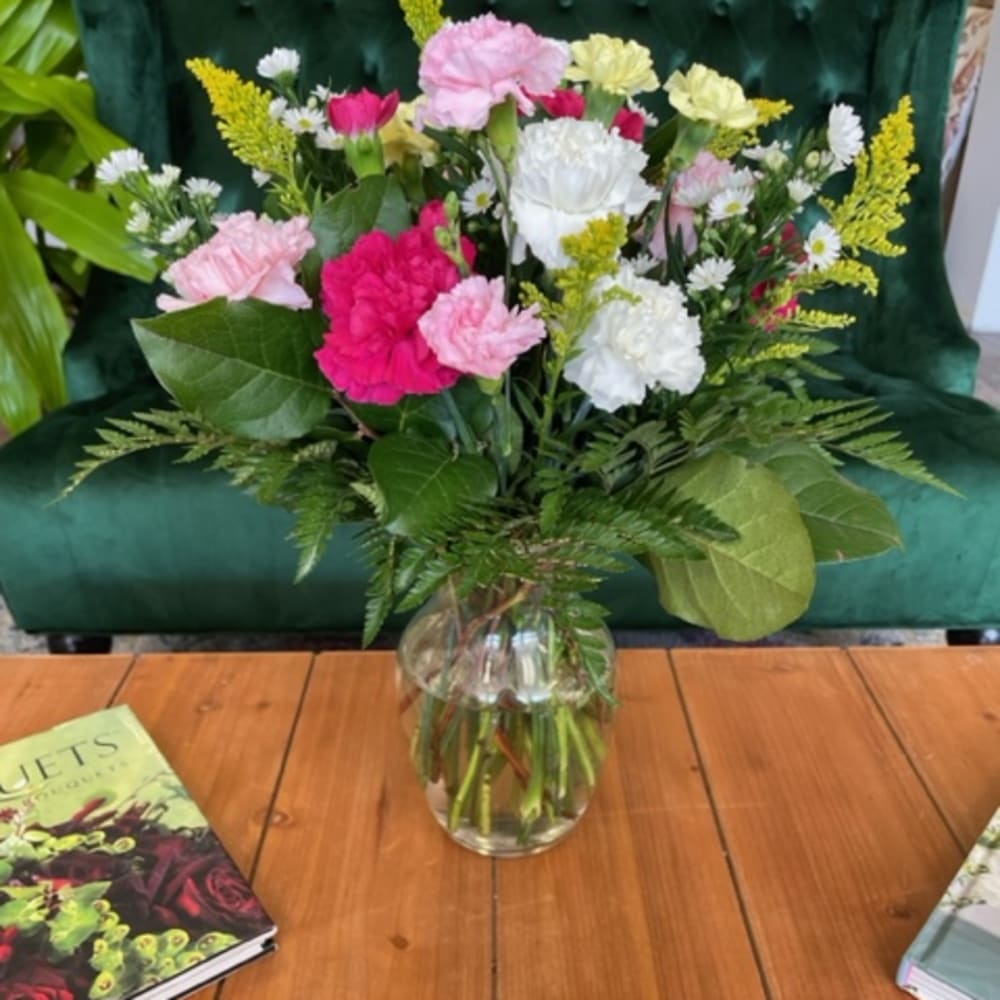 Mixed pink and white carnations in a clear glass vase