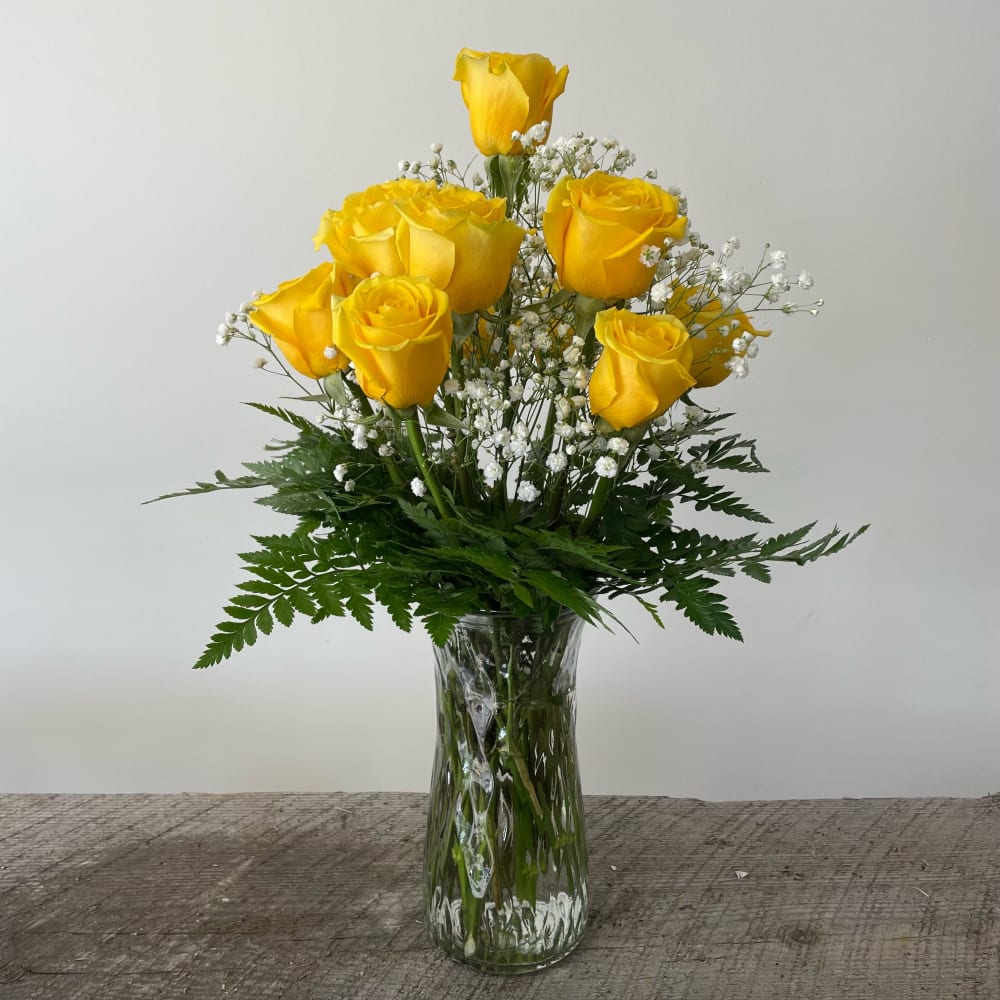 Yellow roses with baby's breath in a clear glass vase