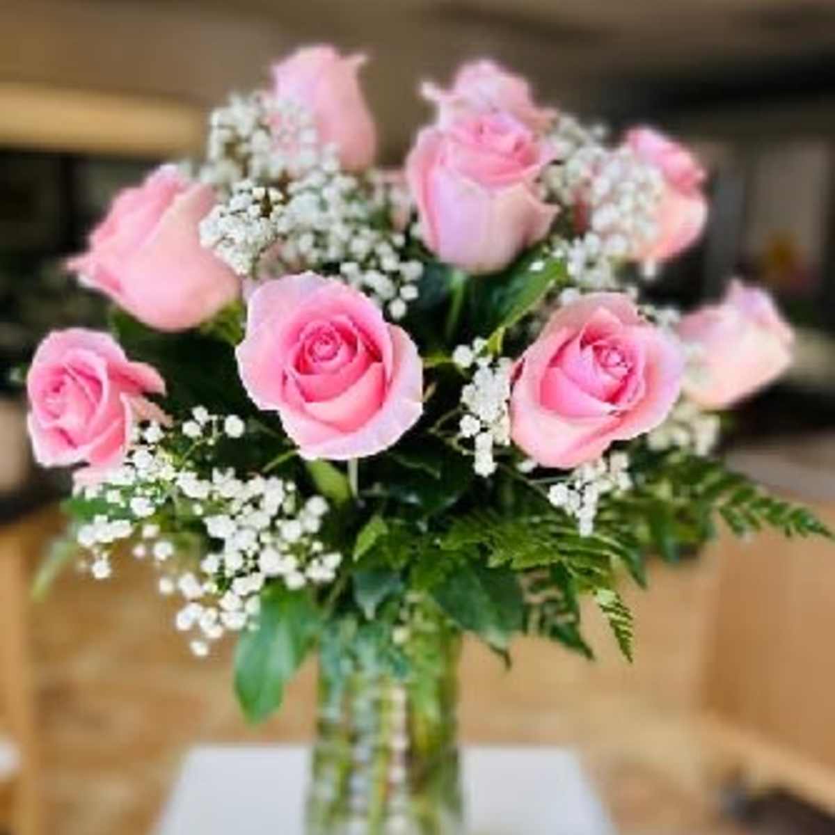 Pink roses and baby's breath in a clear glass vase