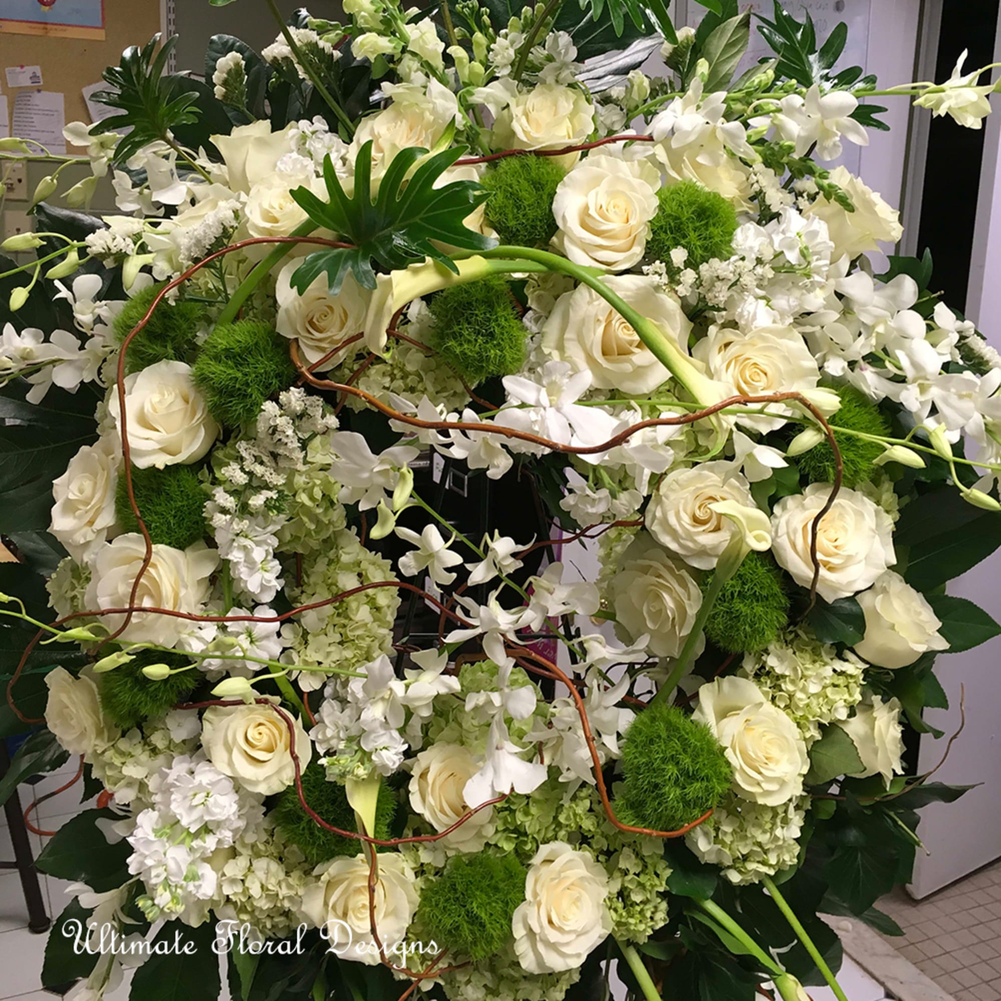 Large white floral arrangement with roses and orchids