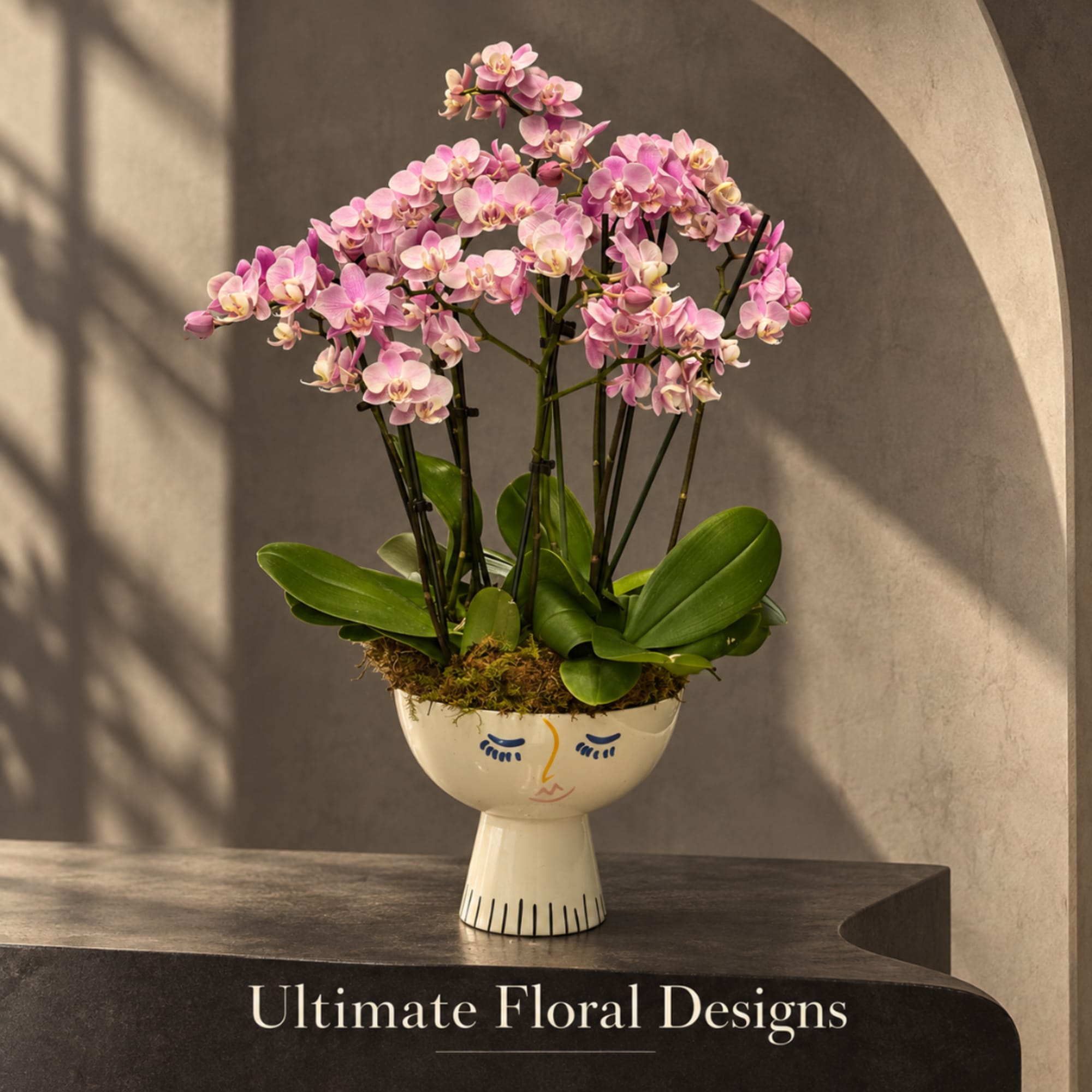Pink orchid arrangement in a decorative face vase