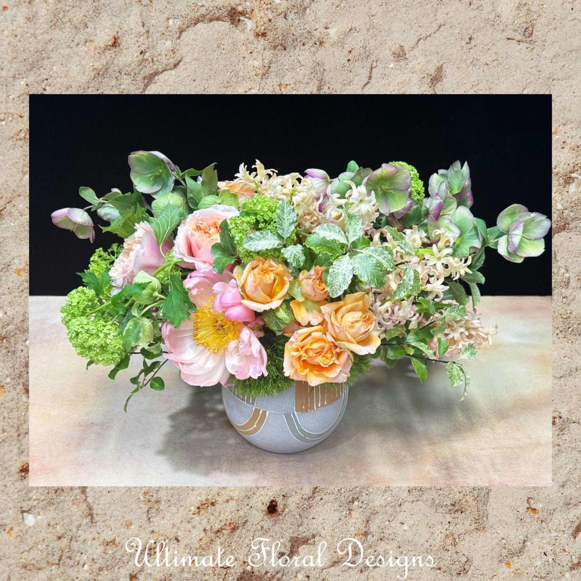 Mixed pastel floral arrangement in a round ceramic vase