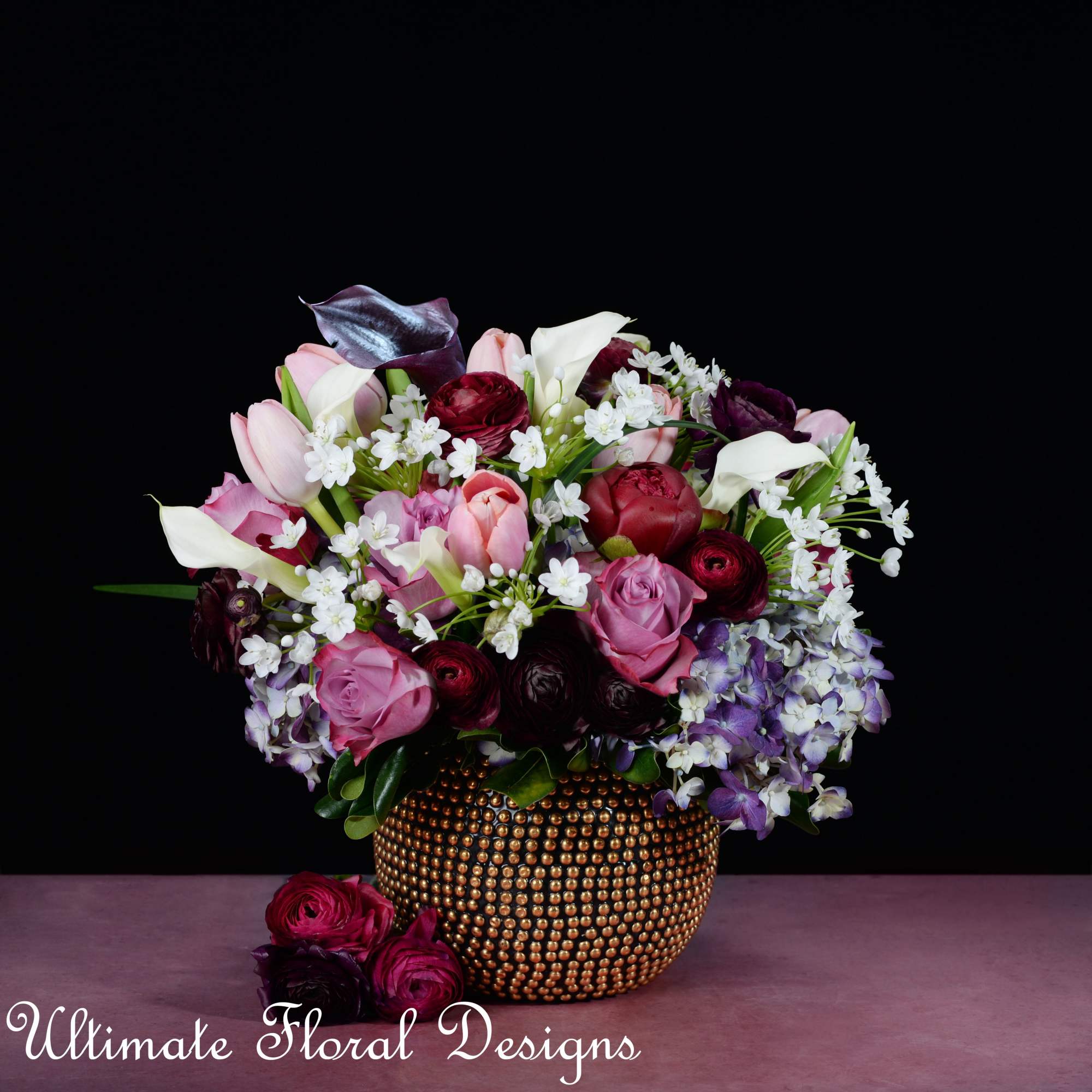 Pink and white flowers arranged in a gold beaded vase.