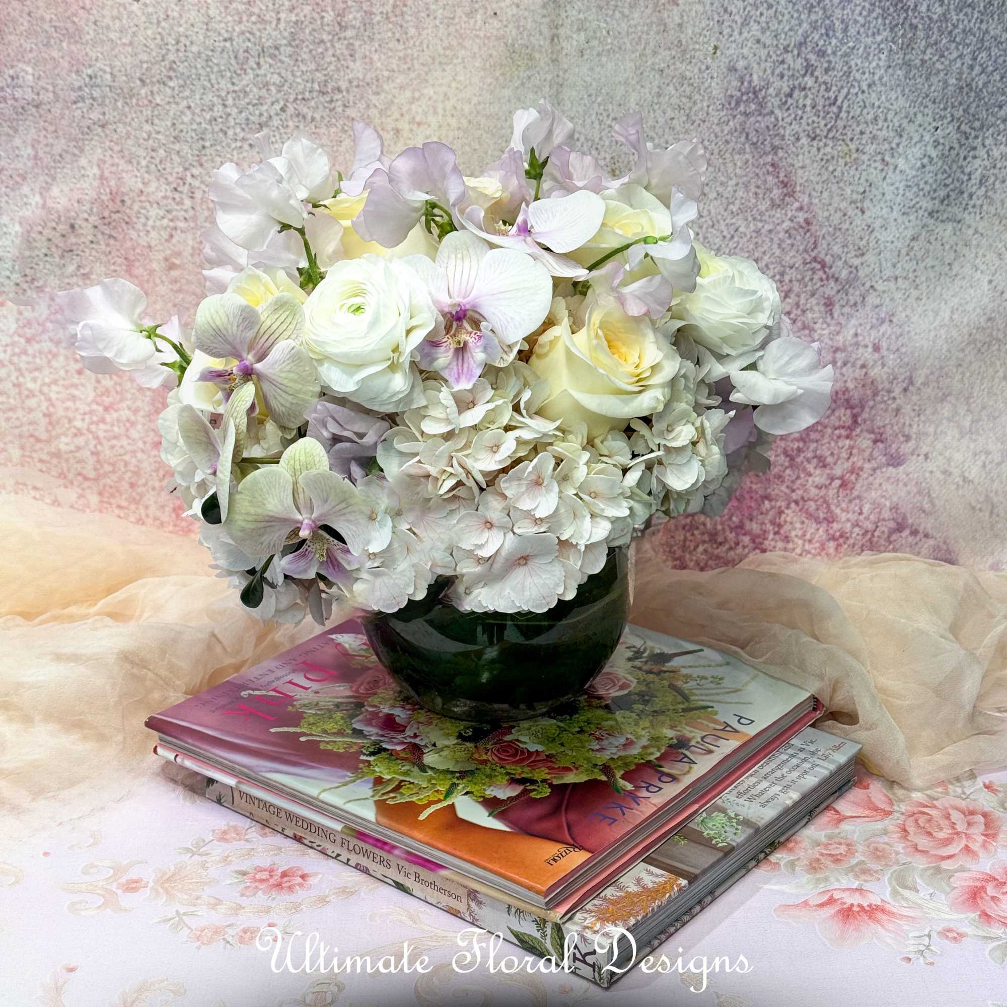 White and pale lavender floral arrangement in a dark glass vase