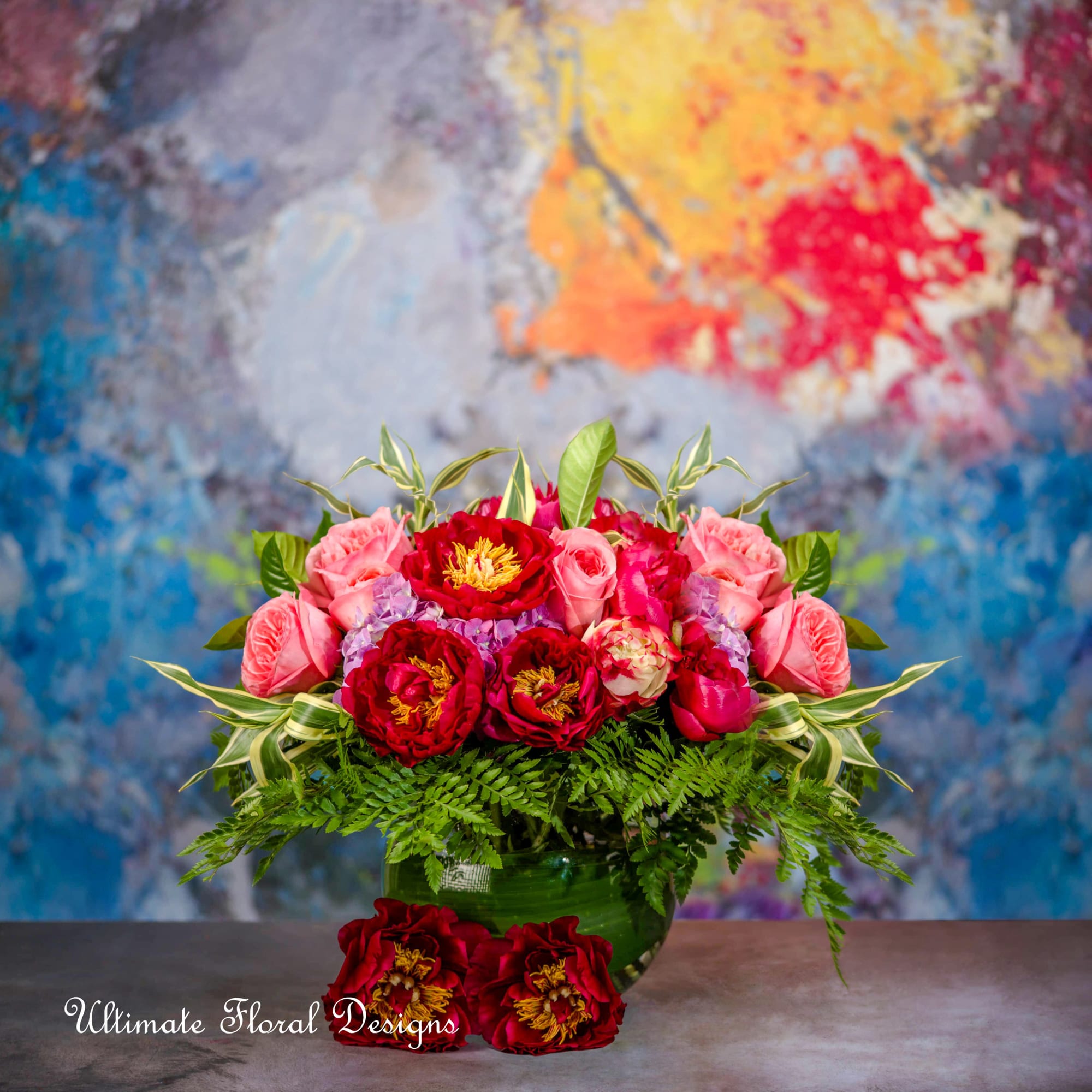 Pink and red flower arrangement in a green vase