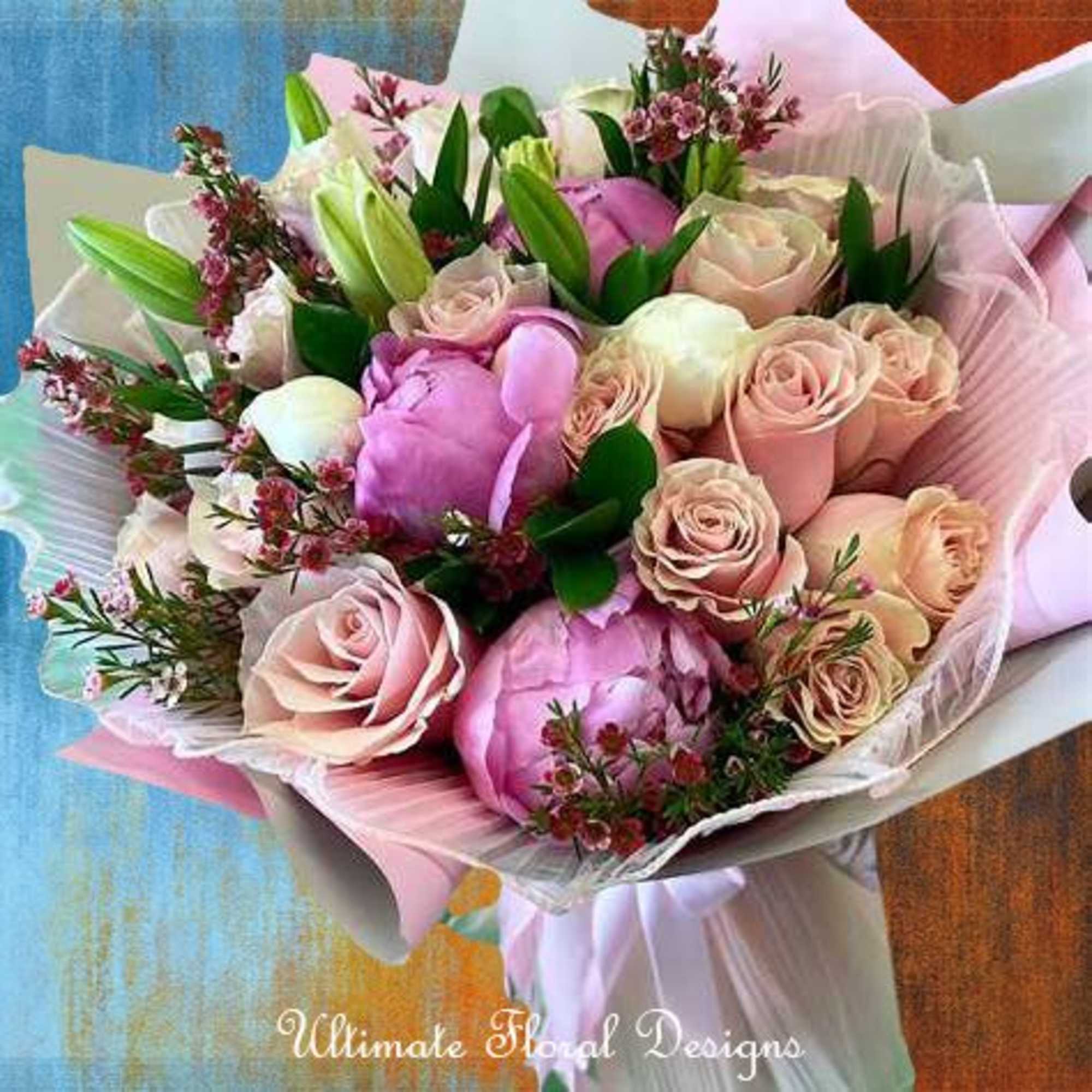 Bouquet of pink roses and lilies wrapped in pale paper