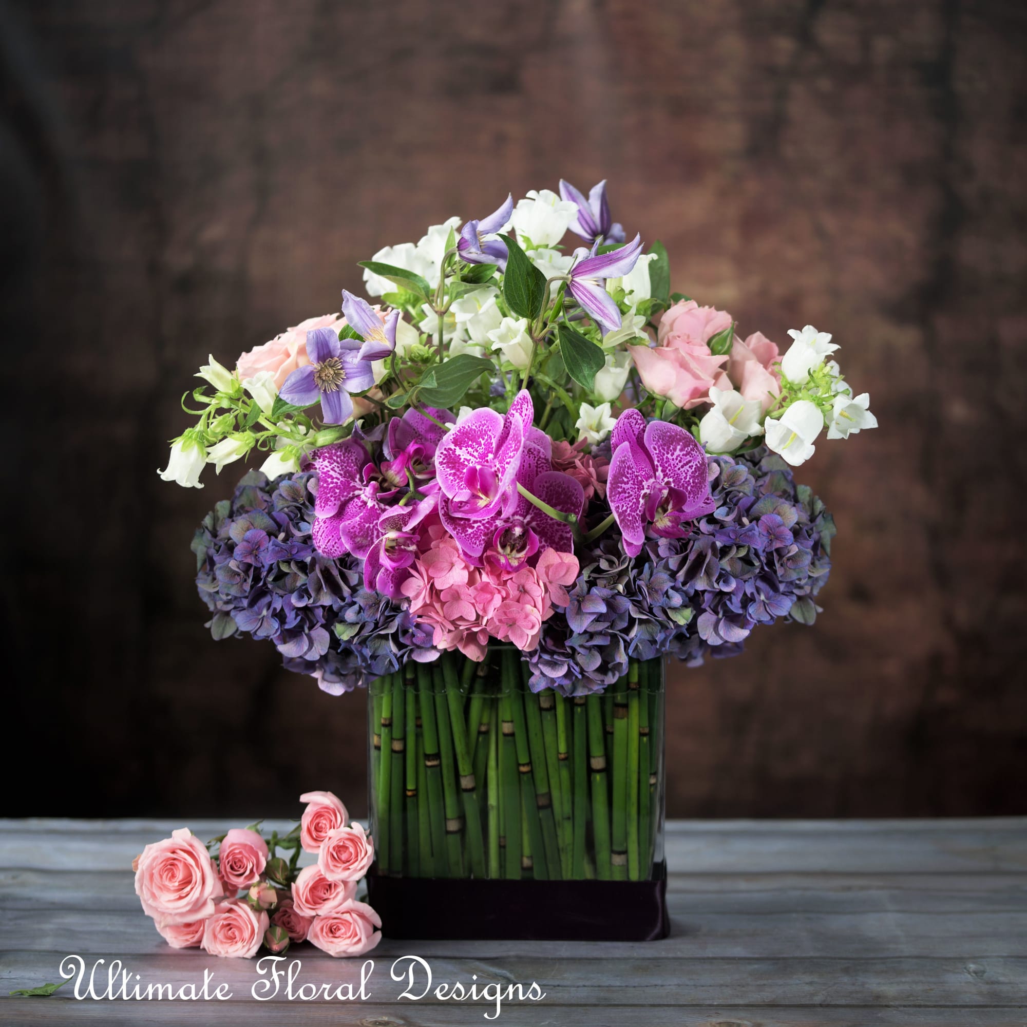 Mixed bouquet in a tall vase with pink, white, and purple flowers