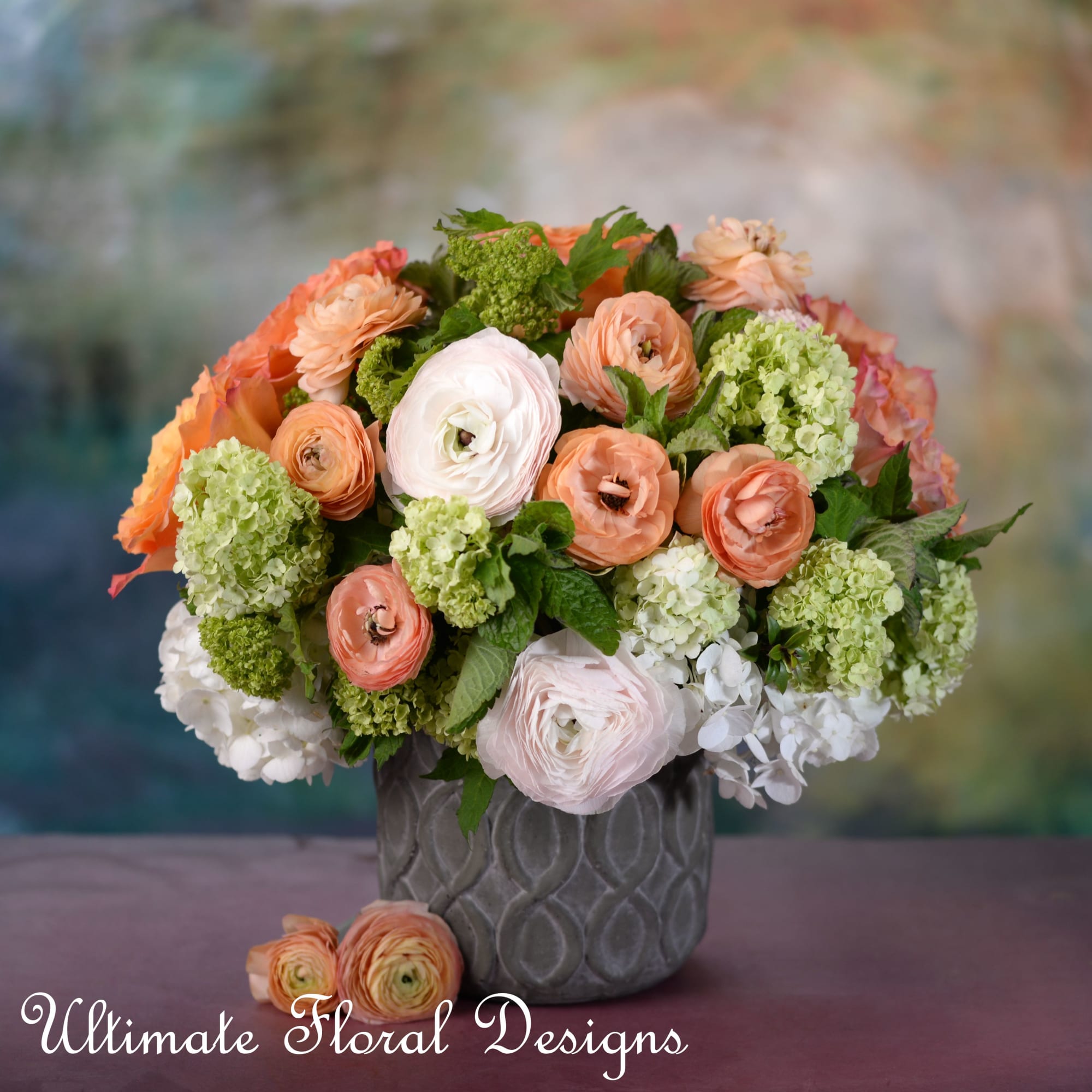 Peach and white flowers arranged in a gray vase