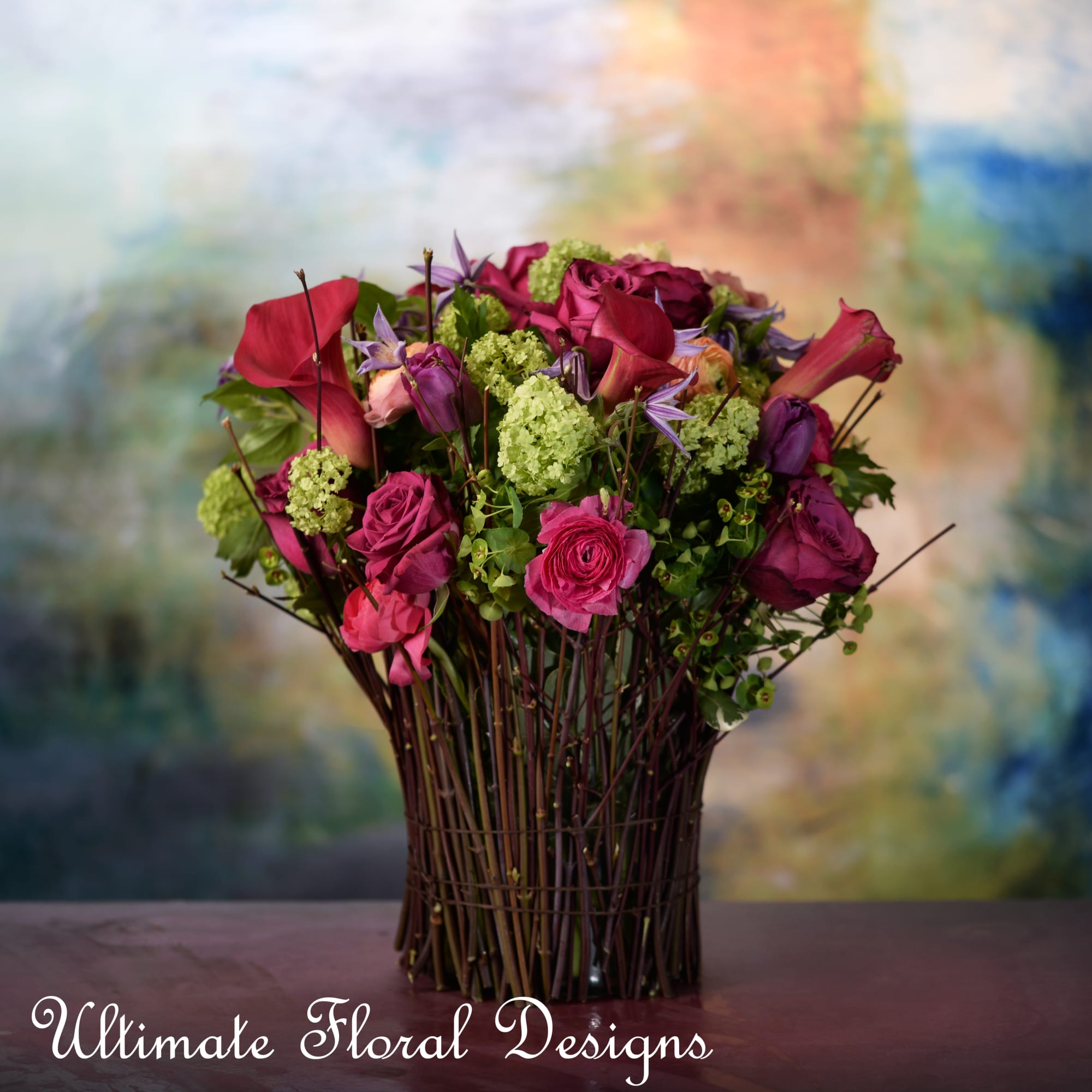 Bouquet of magenta roses and calla lilies in a tall vase