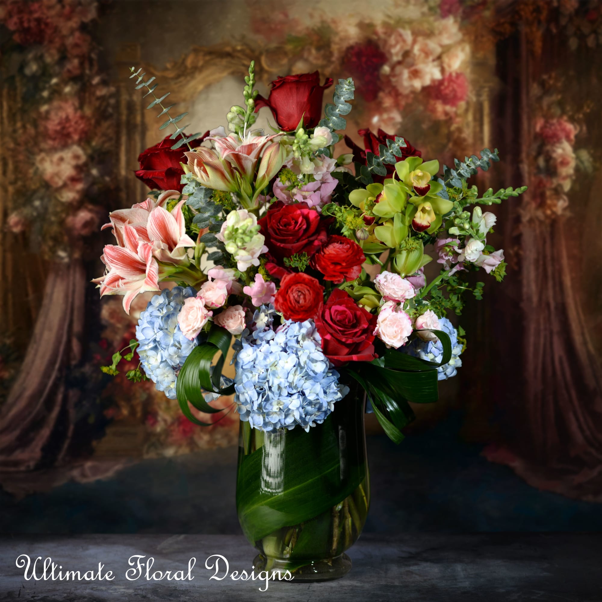 Mixed bouquet of red roses, lilies, and blue hydrangeas in a glass vase