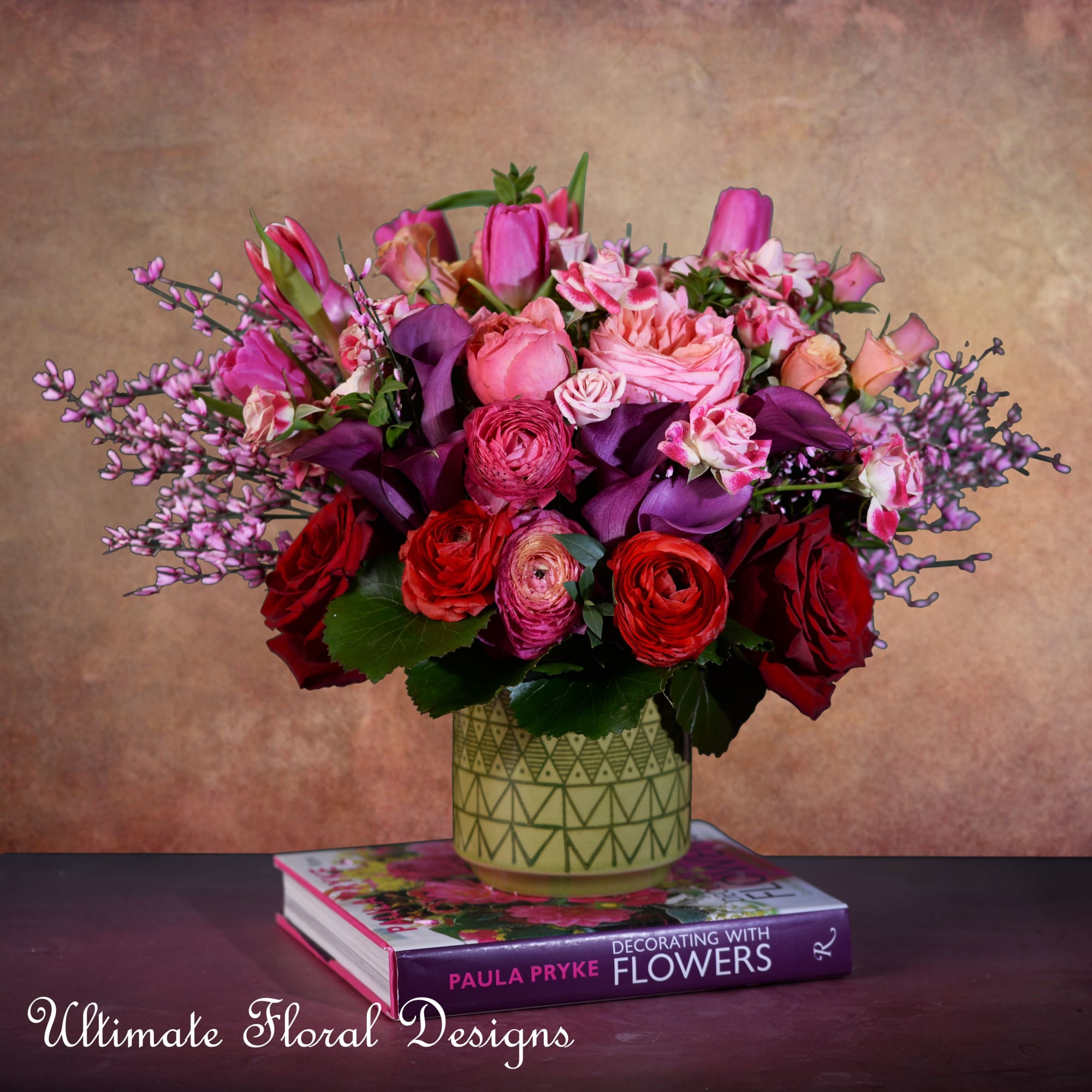 Pink and red mixed bouquet in a patterned vase