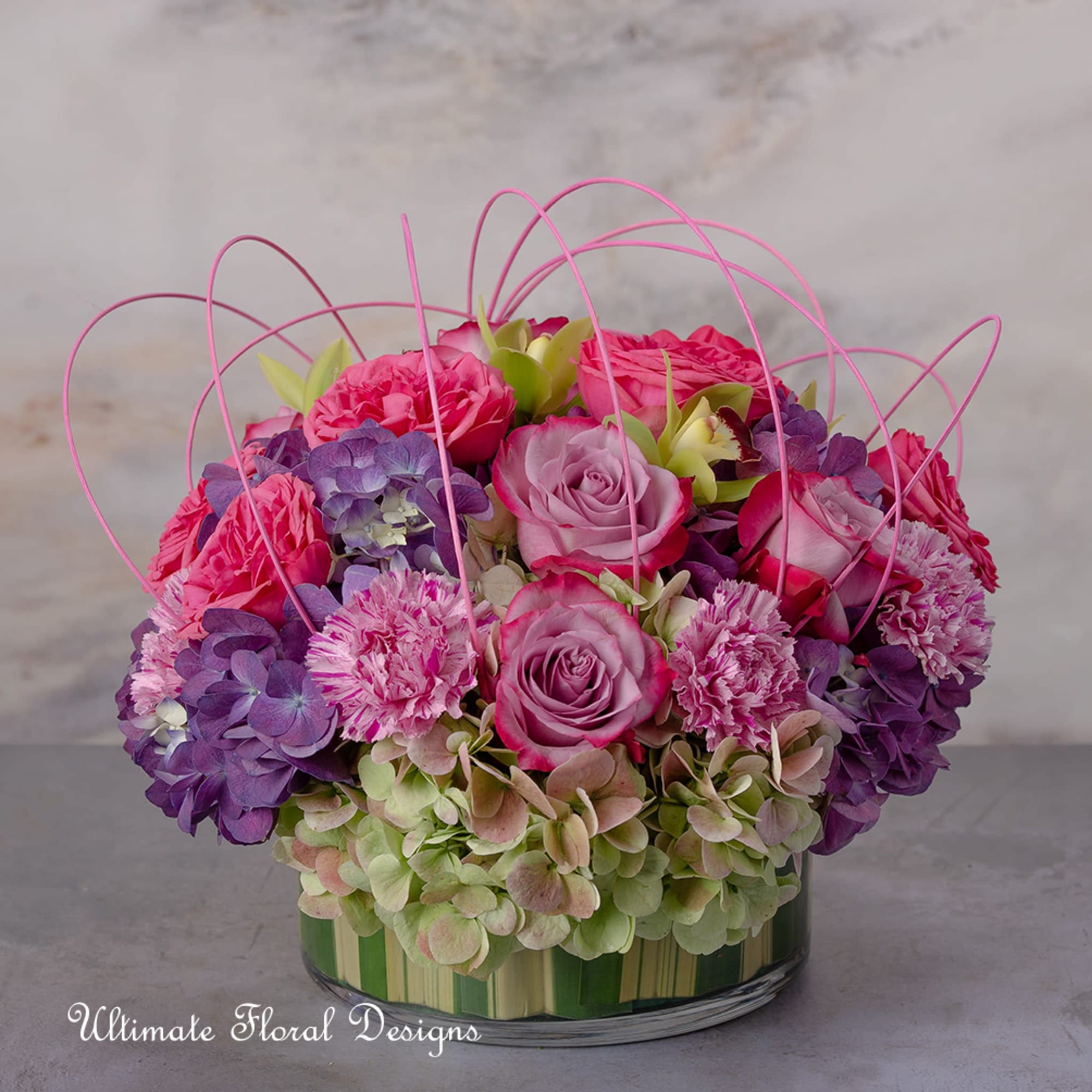 Pink and purple roses with hydrangeas in a glass vase