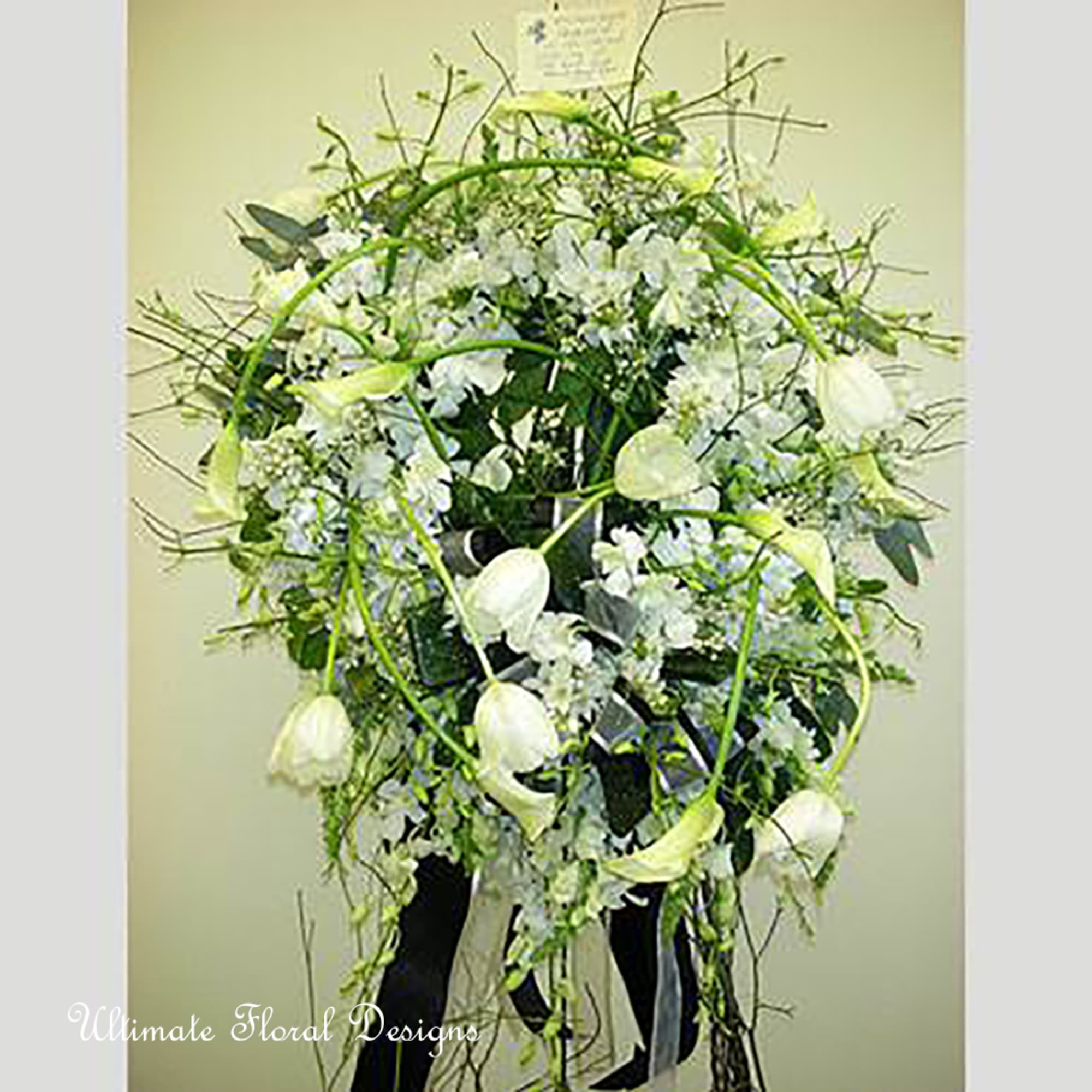 Tall white floral arrangement with arching stems and hanging blooms