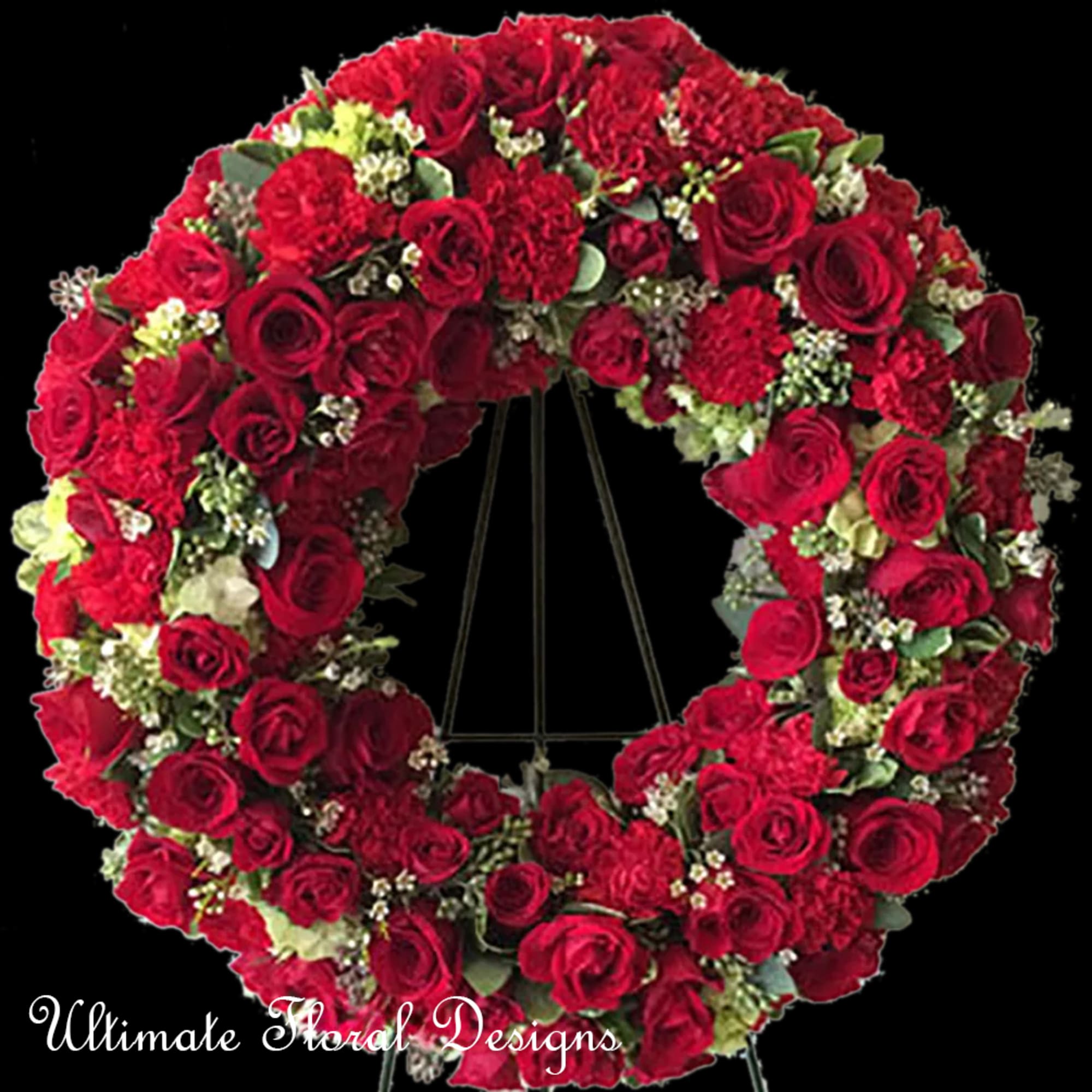 Large heart-shaped wreath of red roses on a black stand