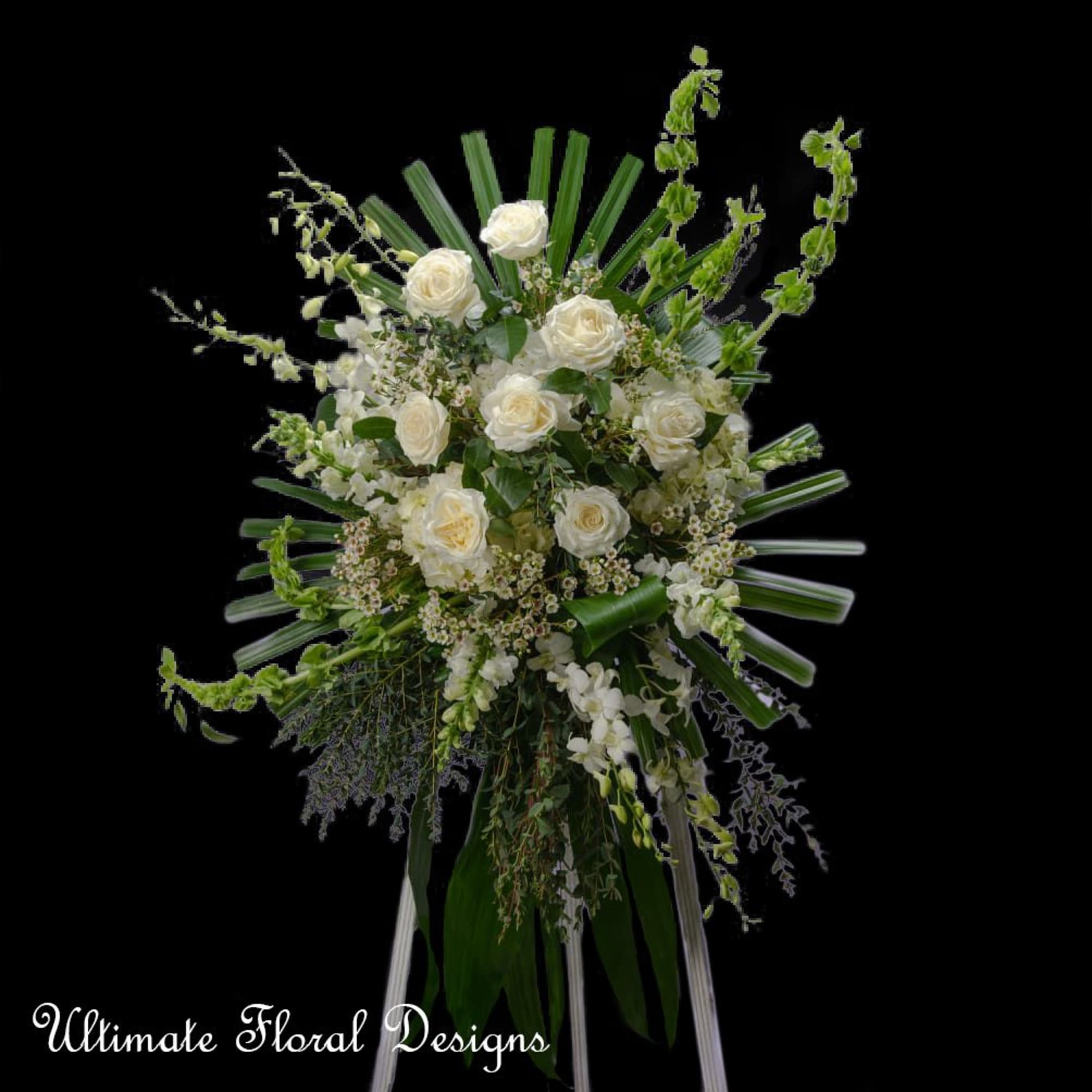 White rose standing spray with cascading greenery on a black background