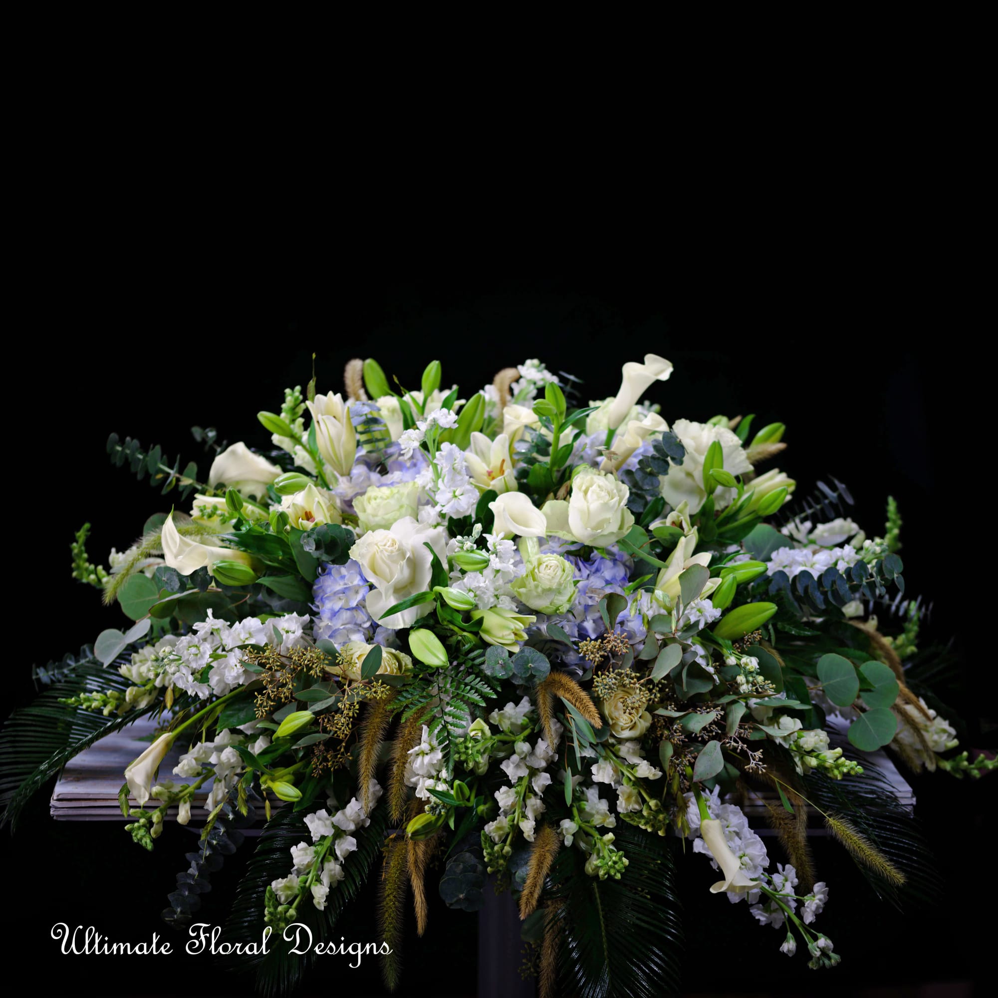 Large white and lavender floral arrangement with calla lilies and roses