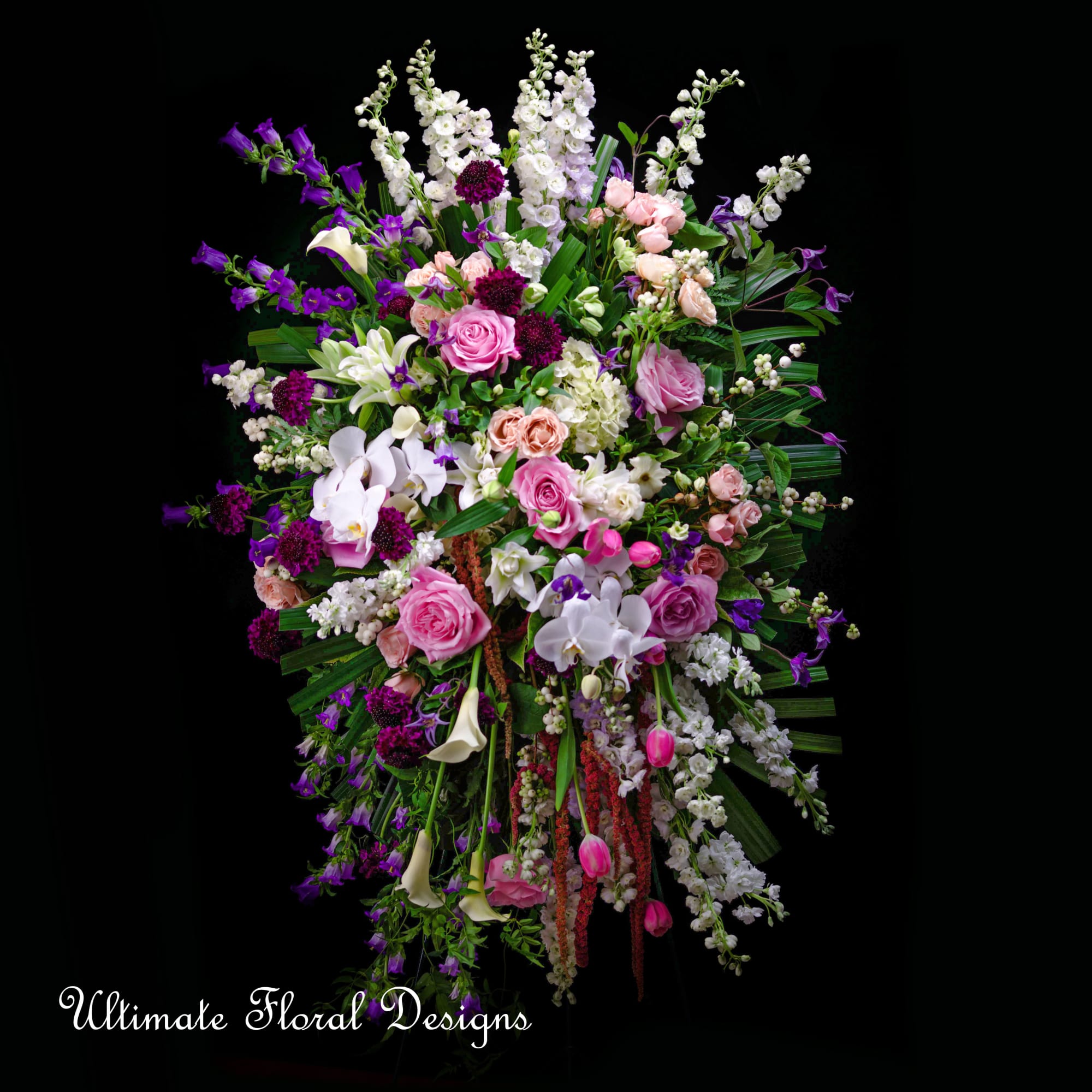 Large standing floral spray with pink, white, and purple blooms