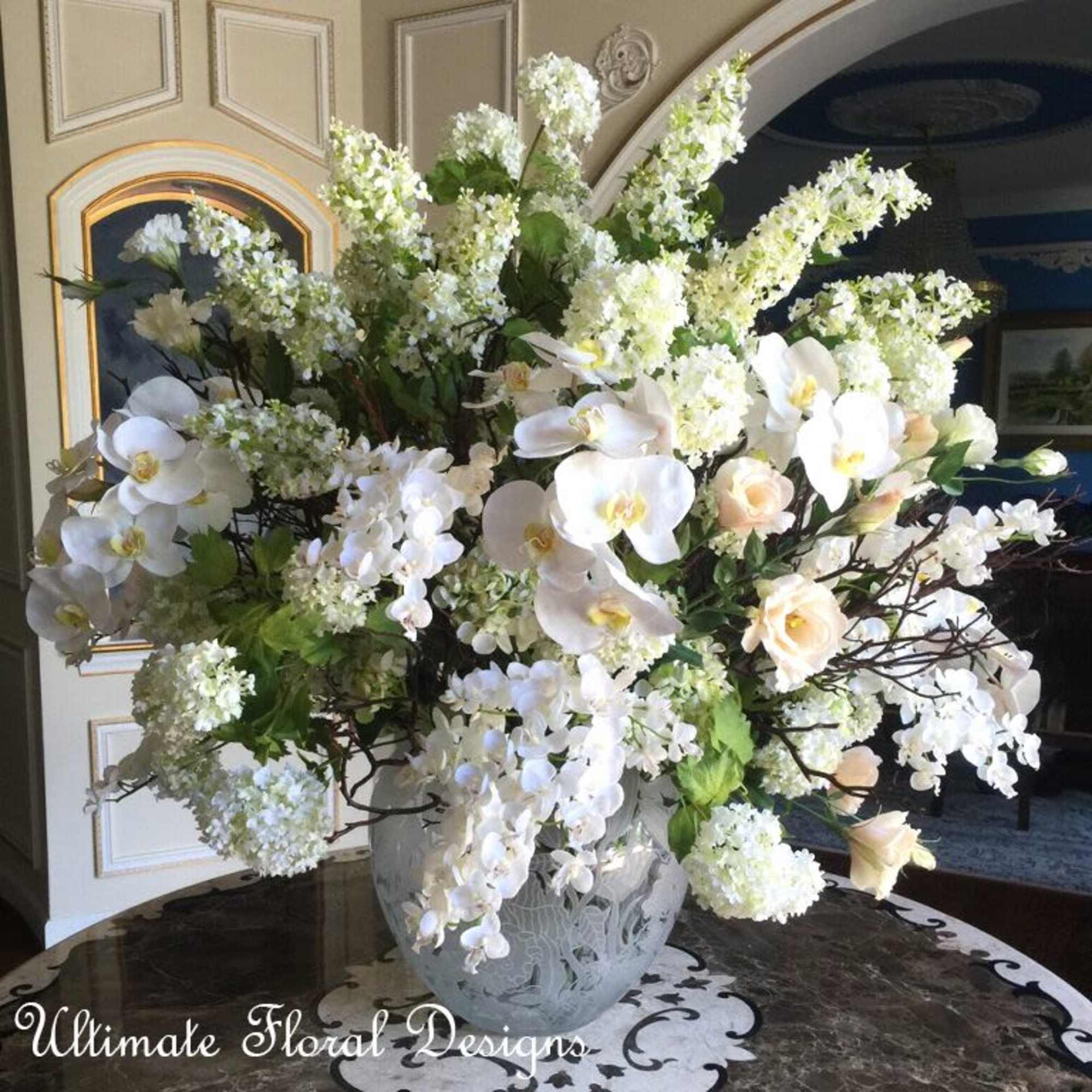 Large white floral arrangement in a decorative vase