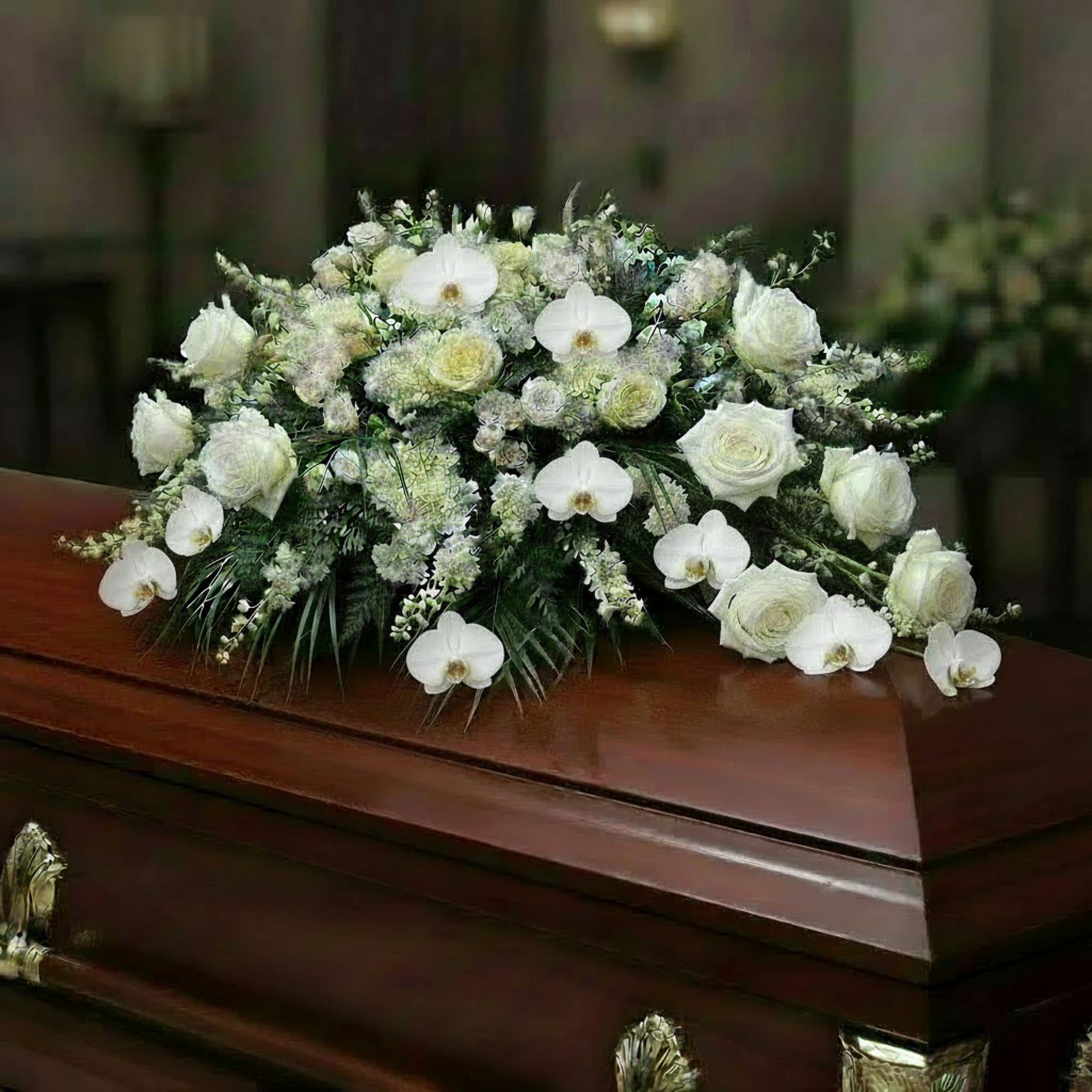White floral casket spray with orchids and roses