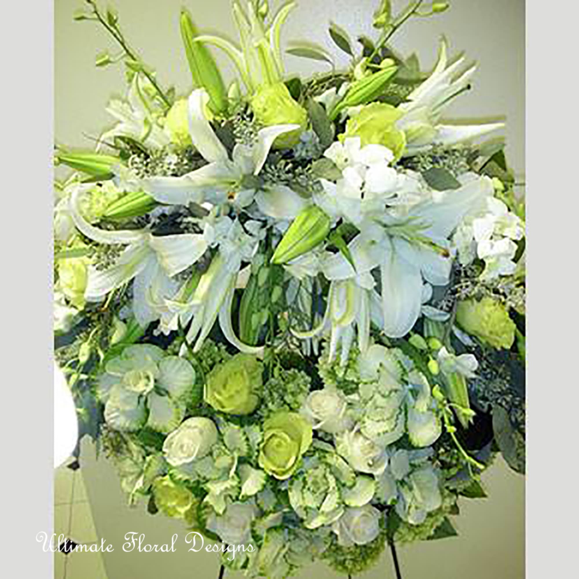Large white and green floral arrangement with lilies and roses