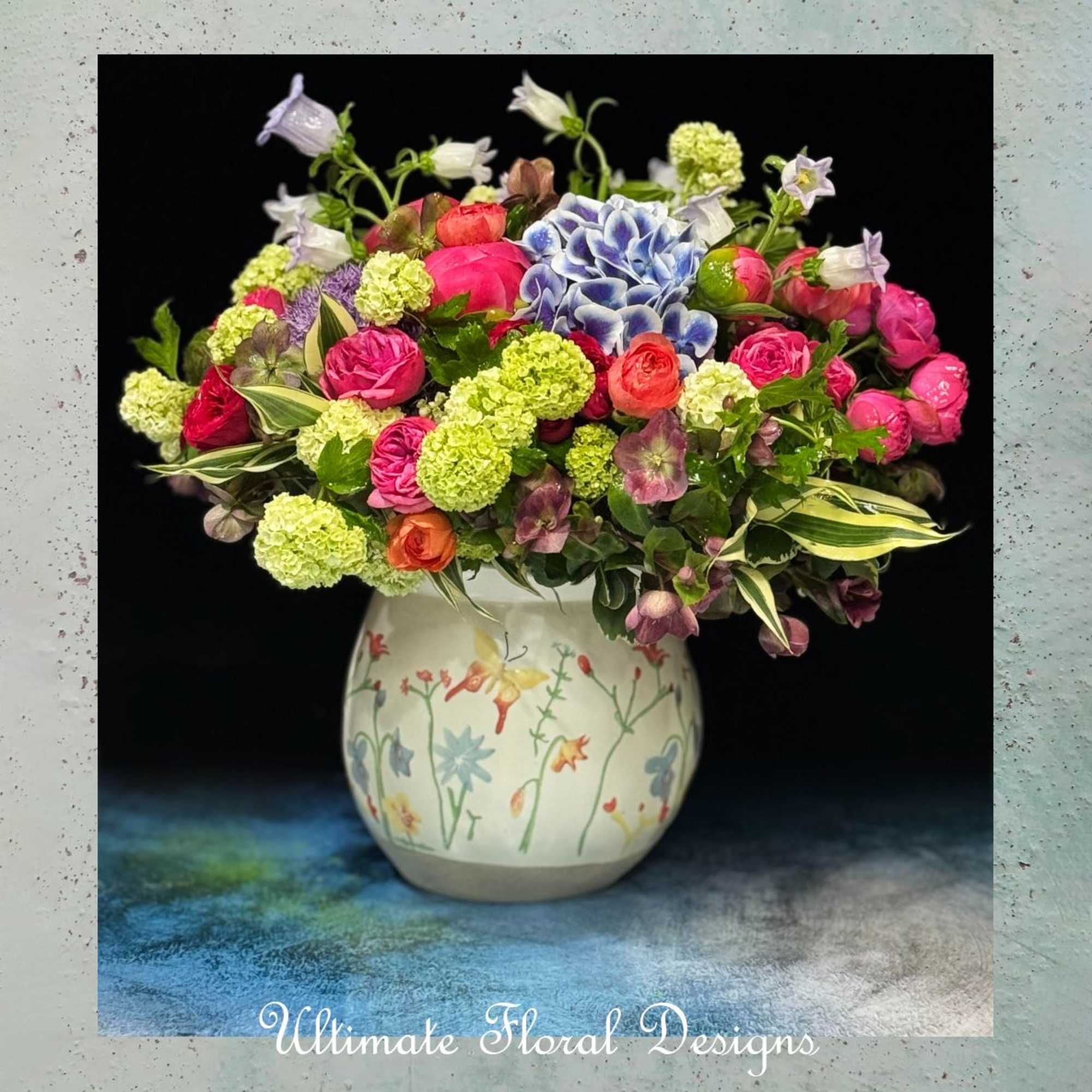 Colorful mixed flower arrangement in a painted ceramic vase
