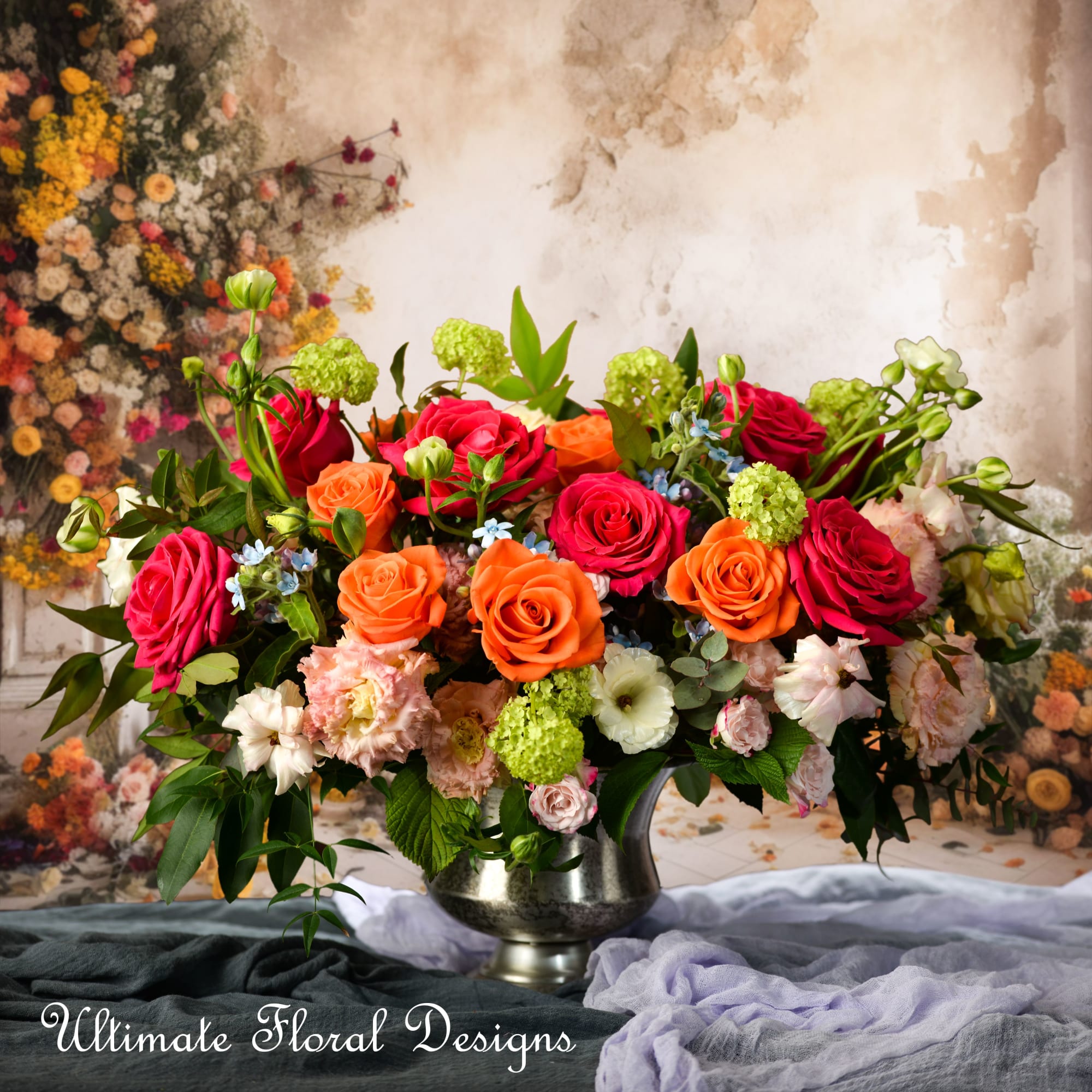Mixed roses in a silver vase with green and pale blooms