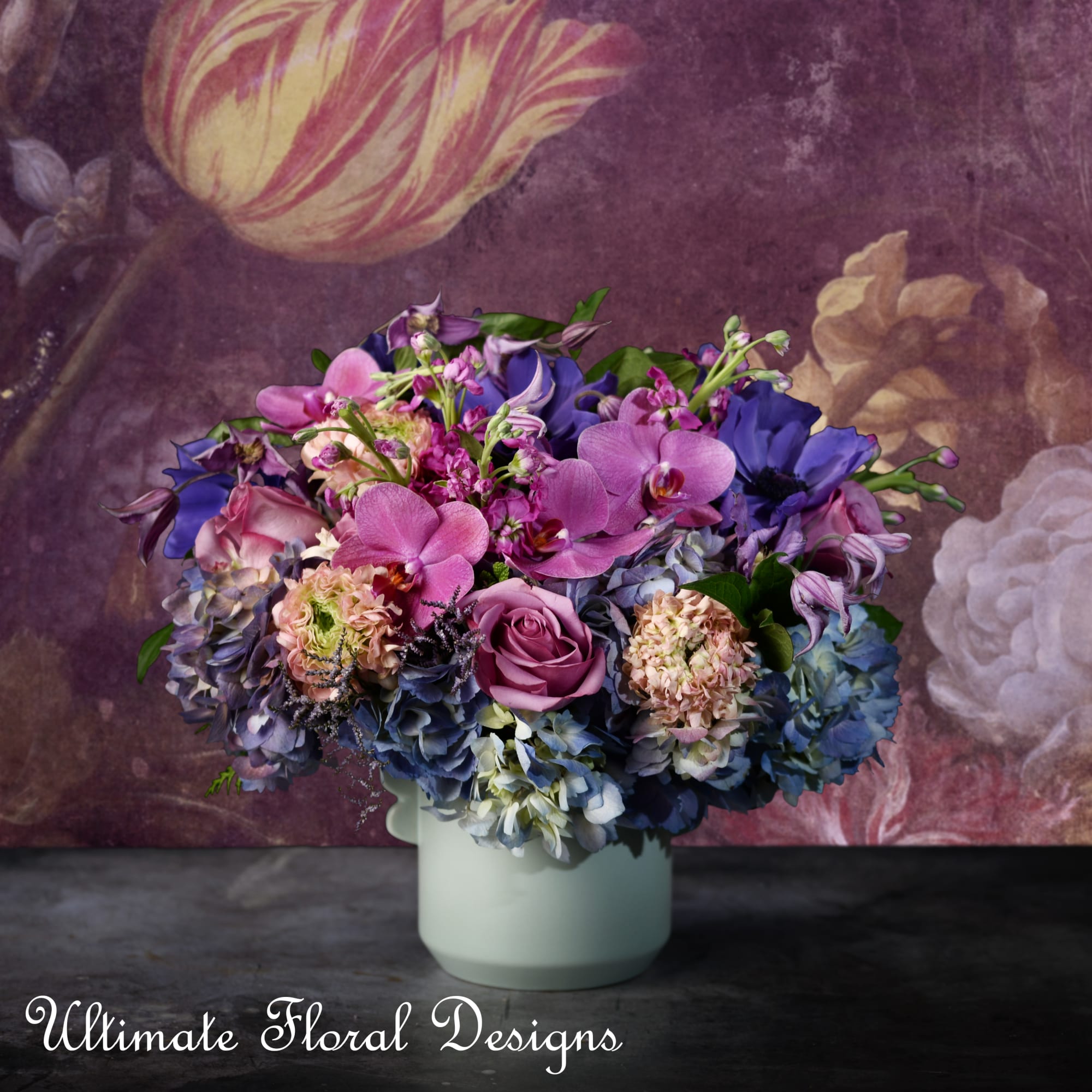 Purple and pink floral arrangement in a pale vase