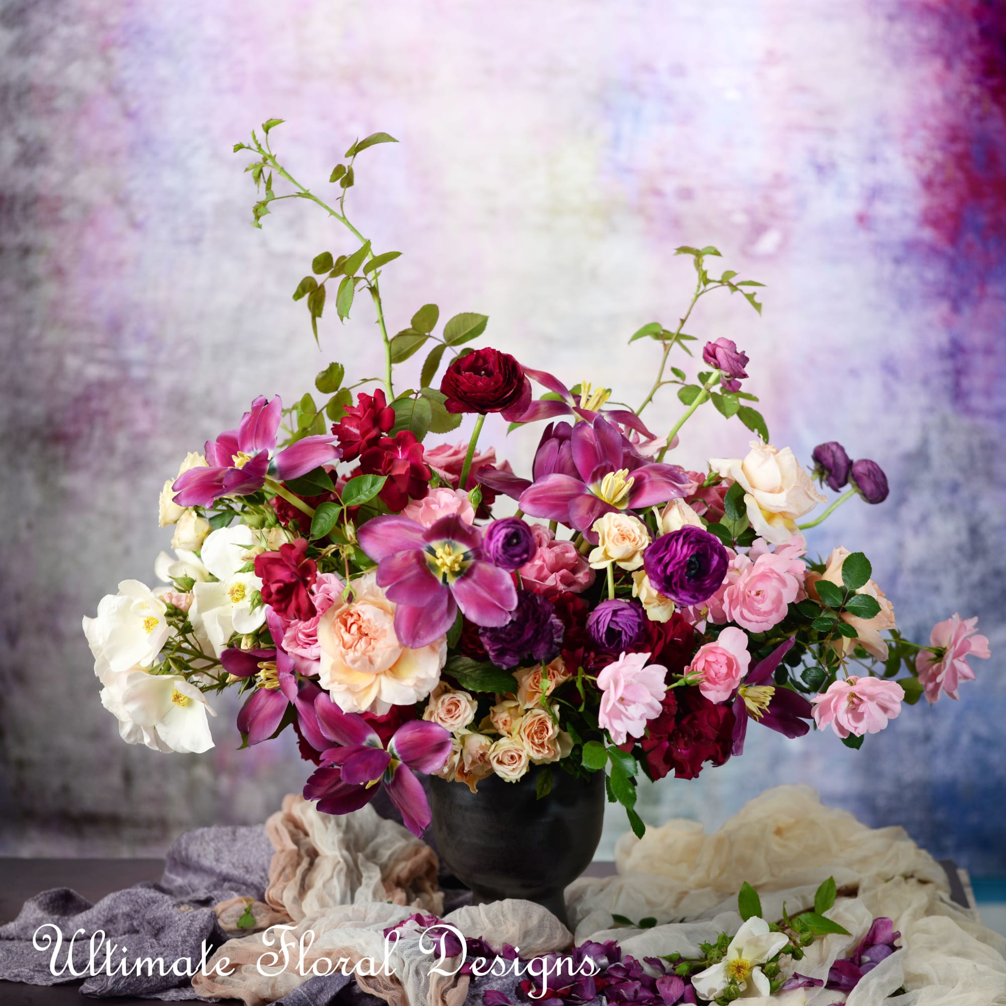 Mixed pink, purple, and white flowers in a black vase