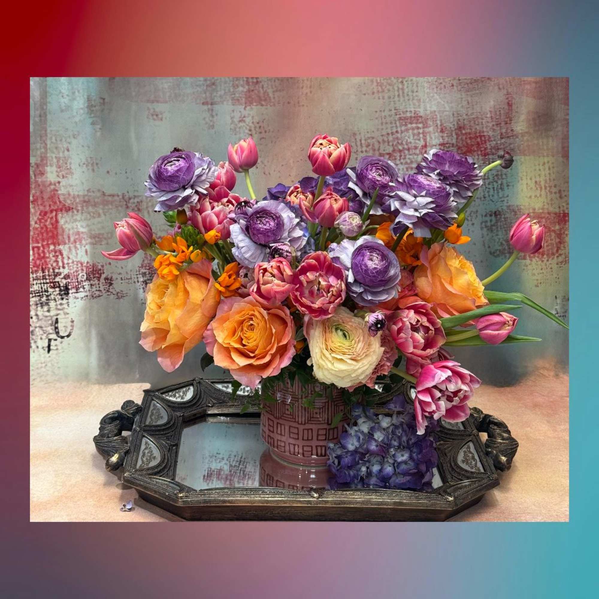 Bouquet of orange, pink, and purple flowers in a patterned vase