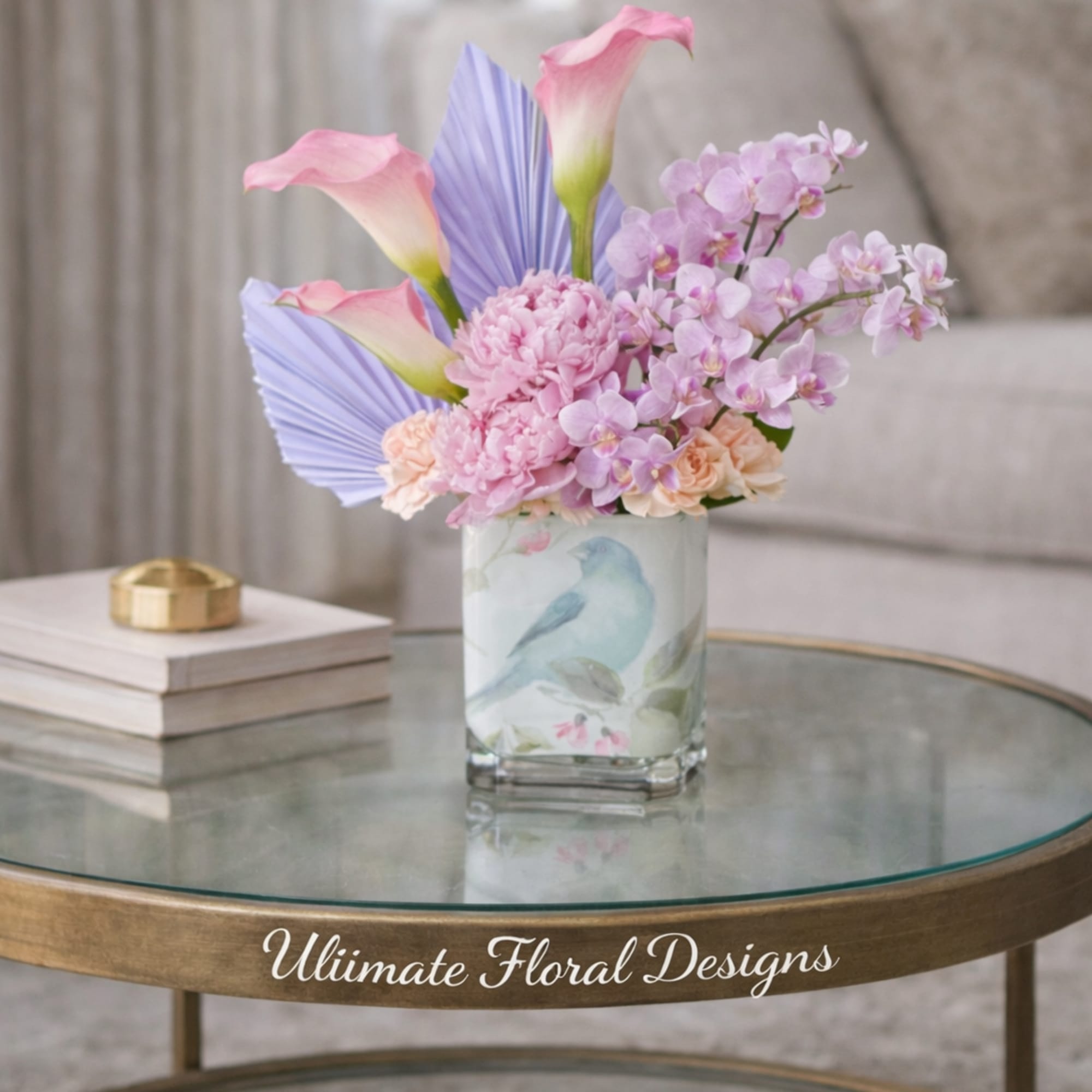 Pink calla lilies and lavender orchids in a glass vase