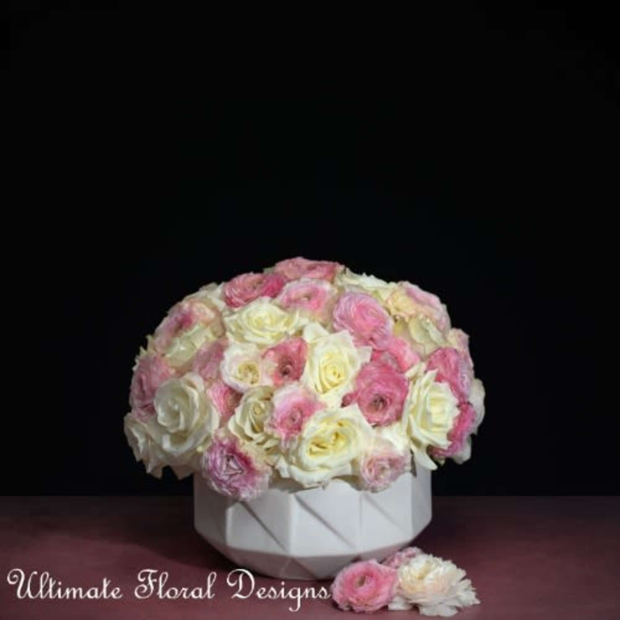Round bouquet of pink and white roses in a white vase