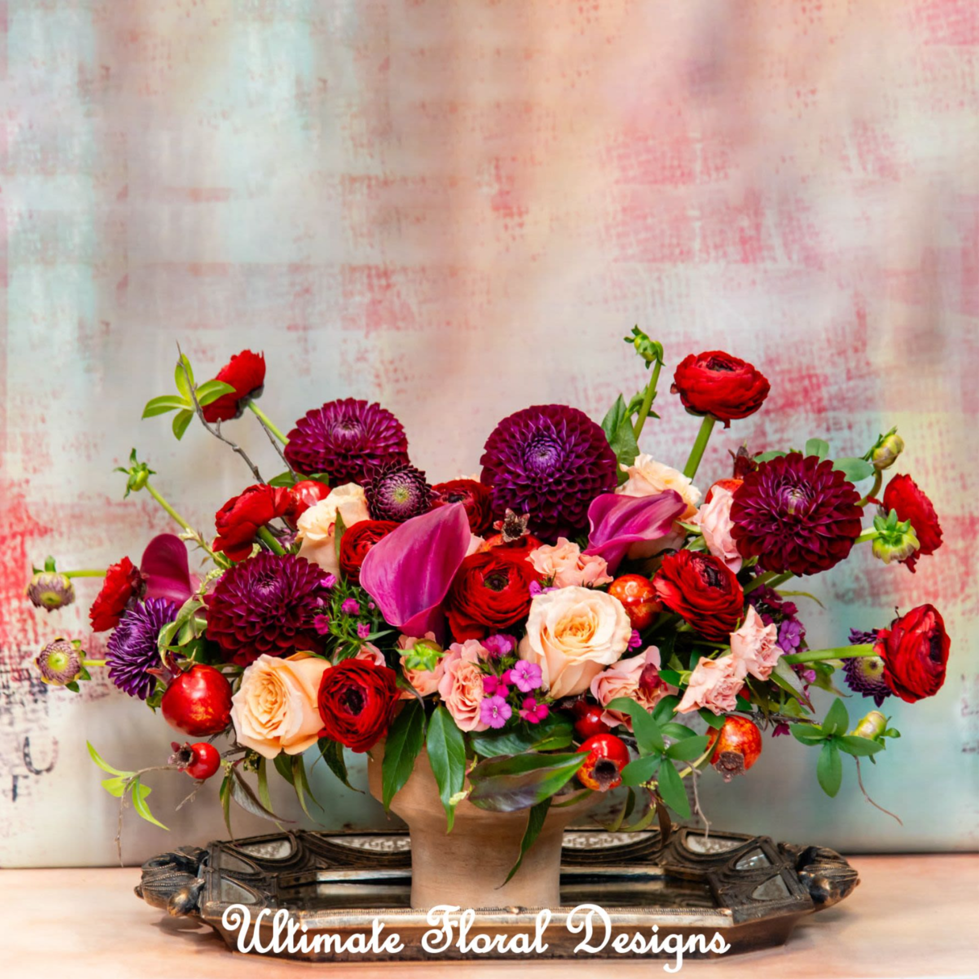 Mixed bouquet of red, pink, and peach flowers in a vase