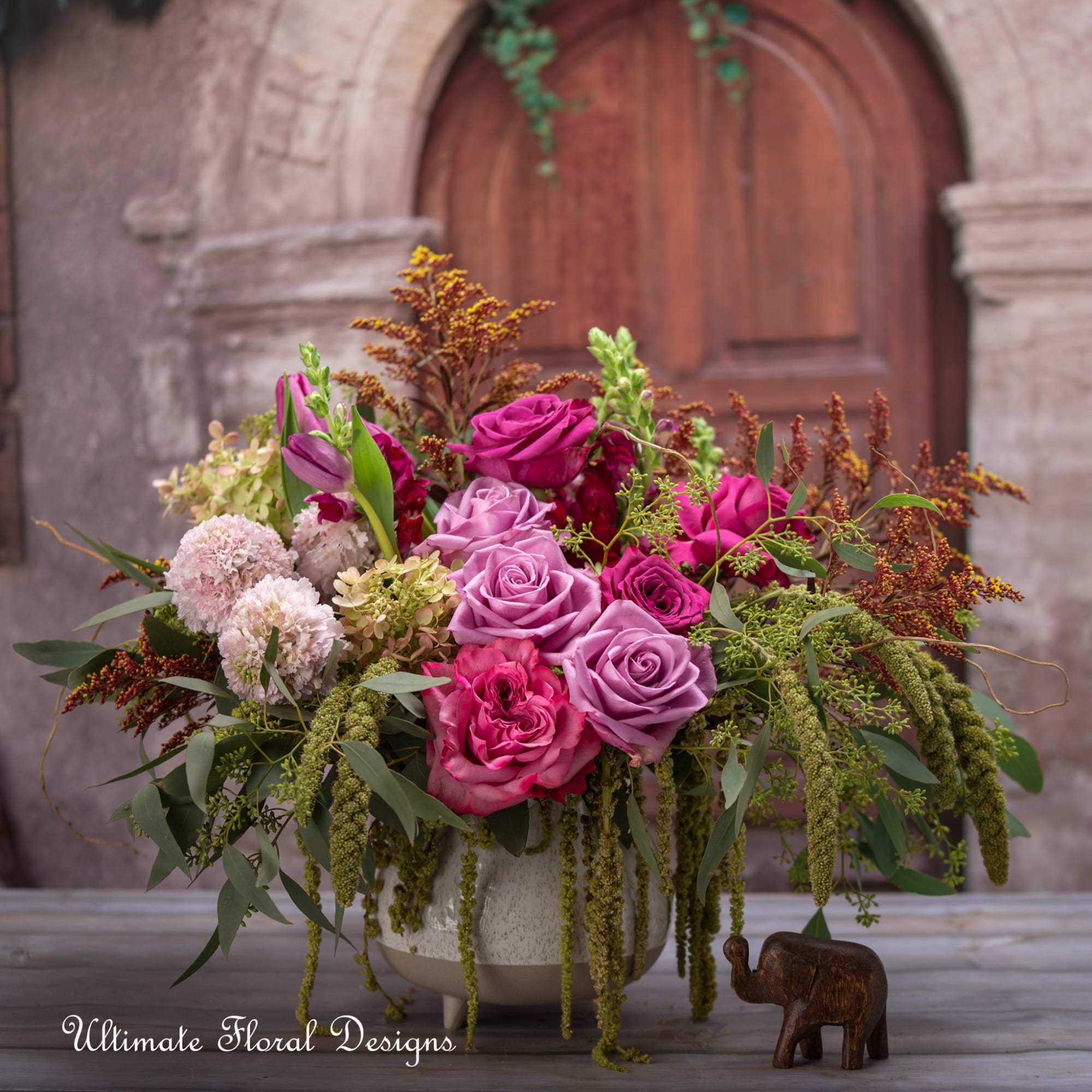 Pink and lavender rose arrangement in a white vase