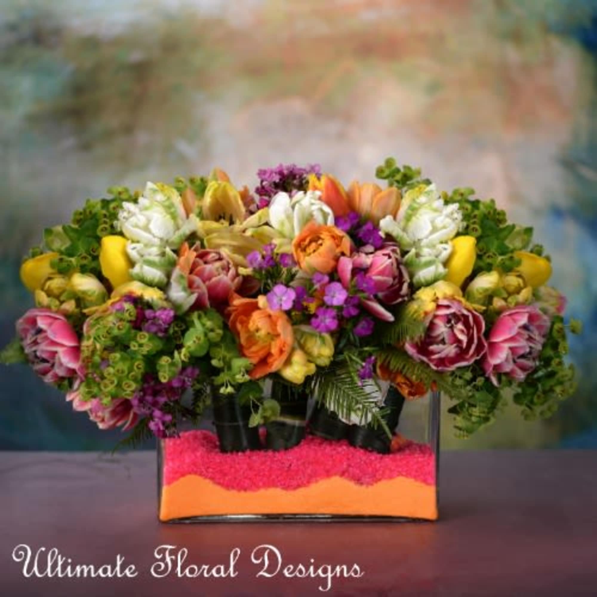 Colorful mixed bouquet in a rectangular glass vase with bright filler