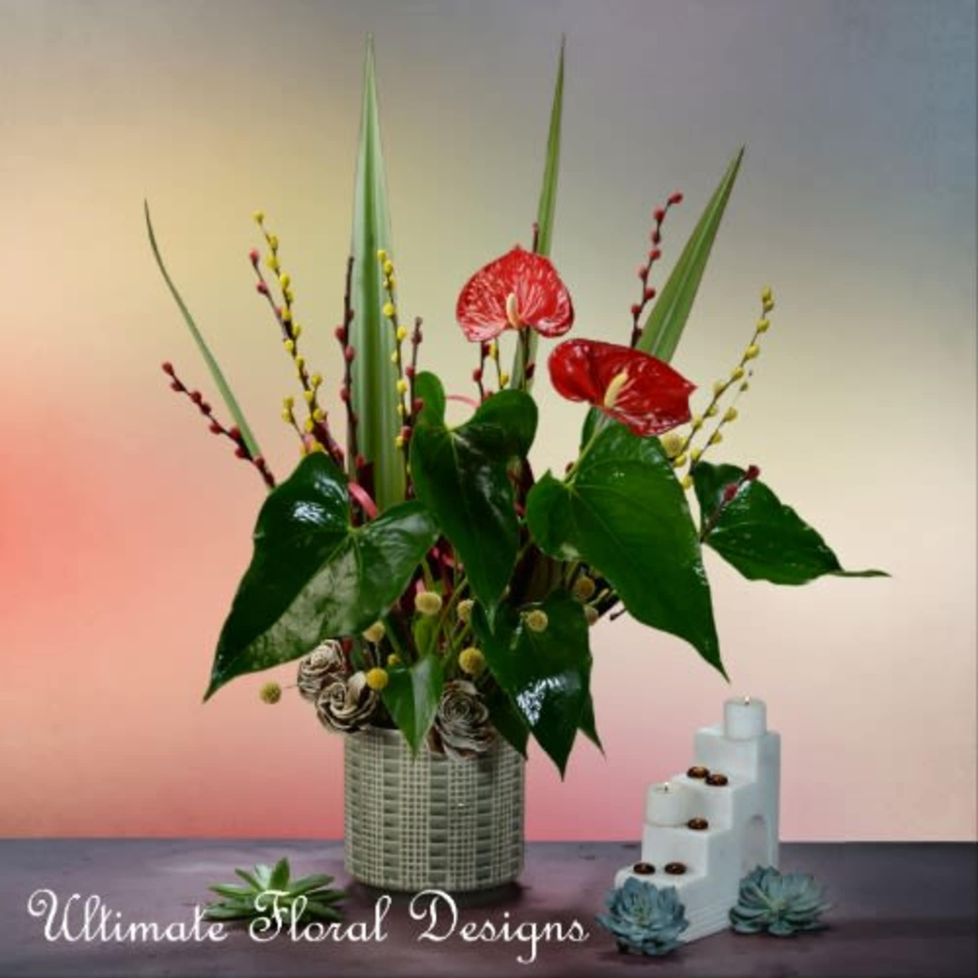 Tropical floral arrangement in a woven vase with red anthuriums and tall leaves