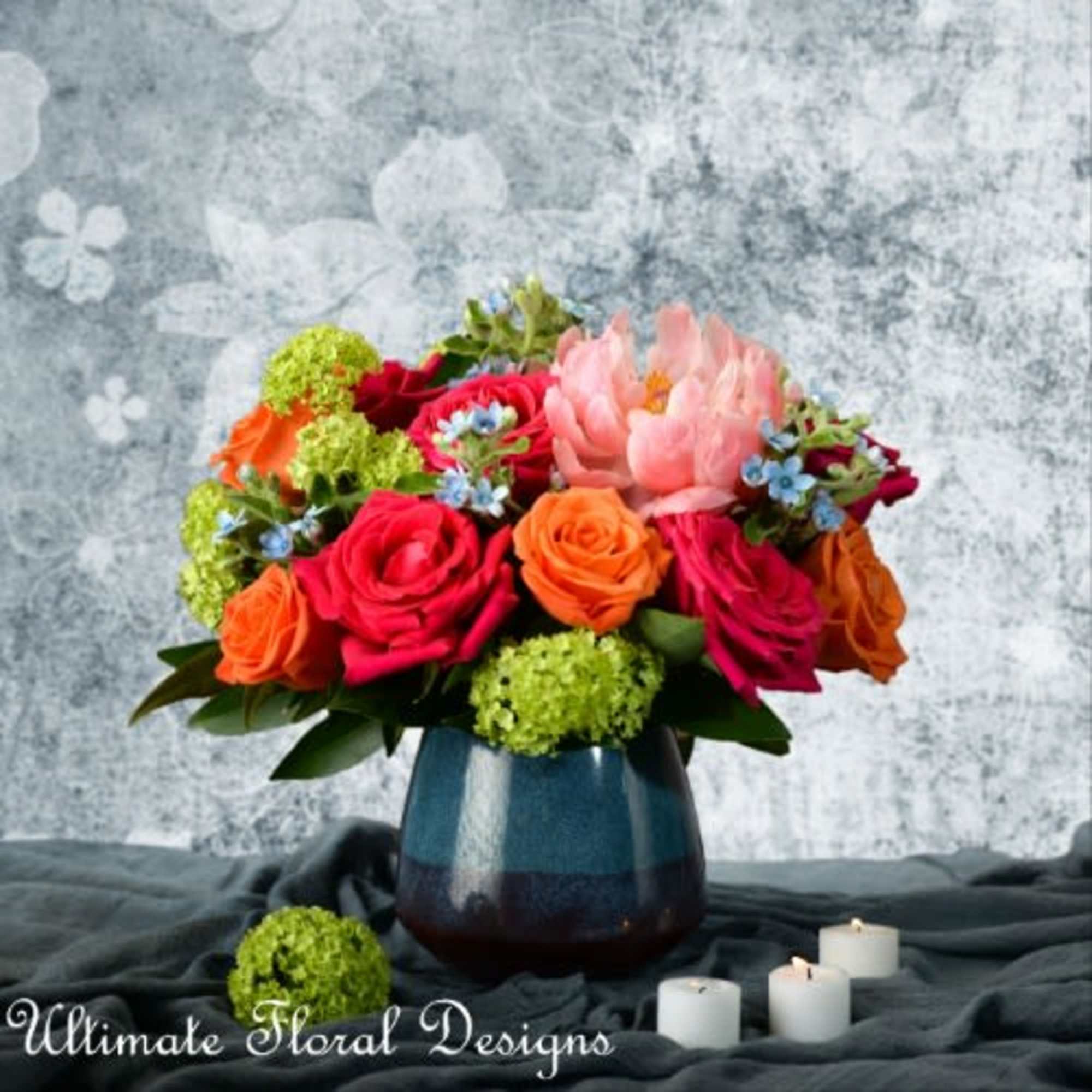 Mixed bouquet of roses and a pink tulip in a blue vase