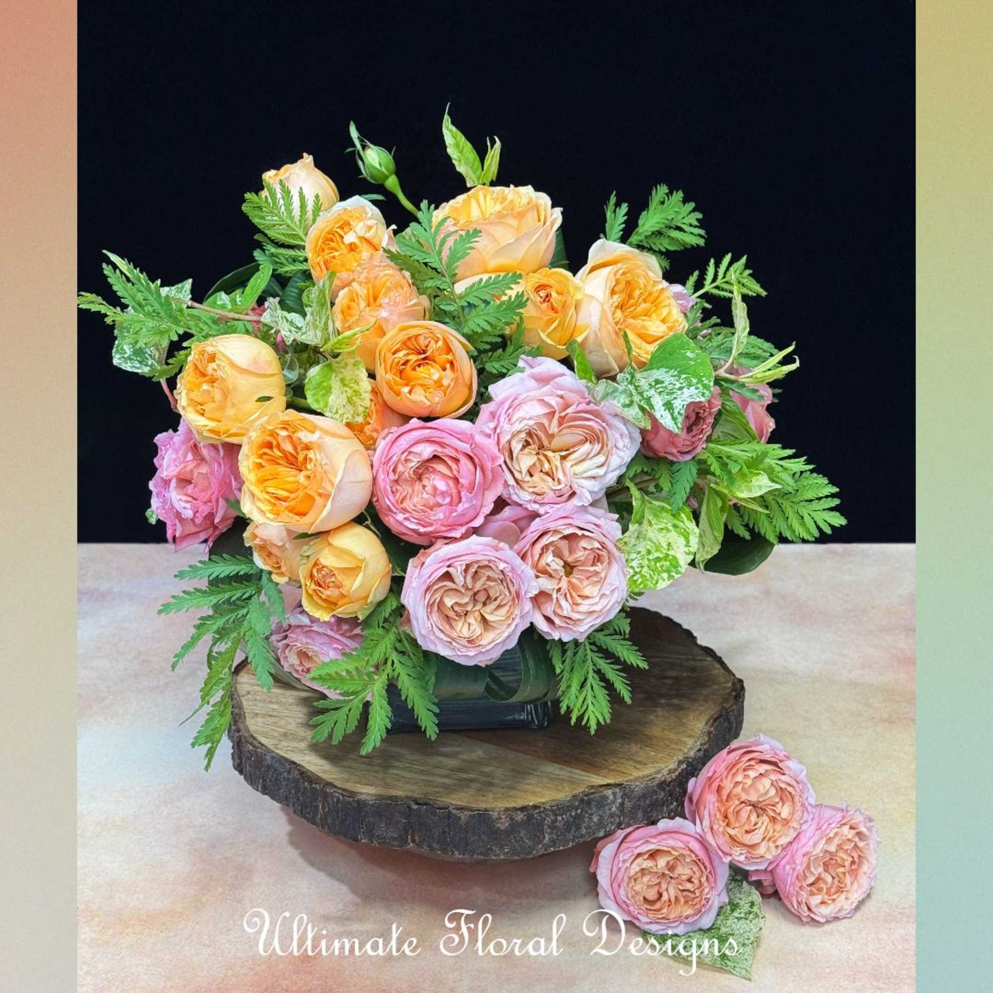 Bouquet of peach and pink roses arranged in a low vase