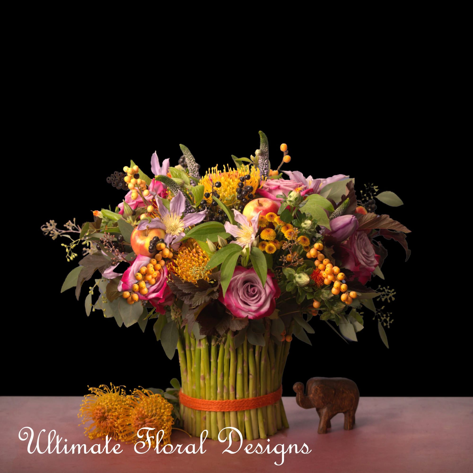 Mixed bouquet with pink roses and orange blooms in a wrapped stem bundle