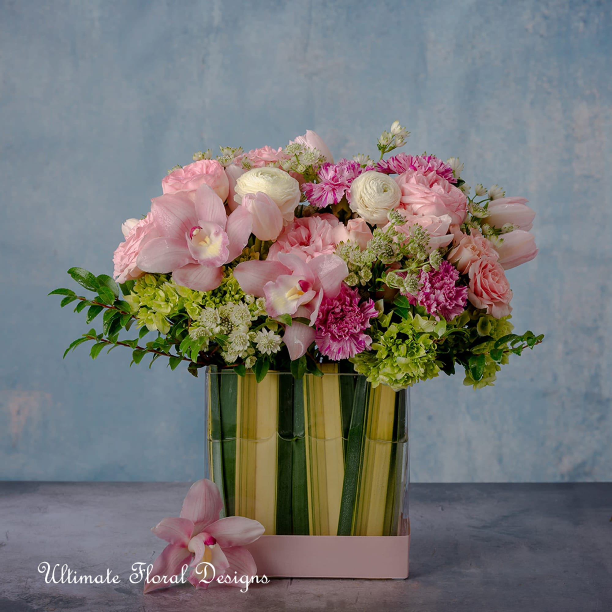 Pink and white mixed bouquet in a glass vase with a pink orchid at the base