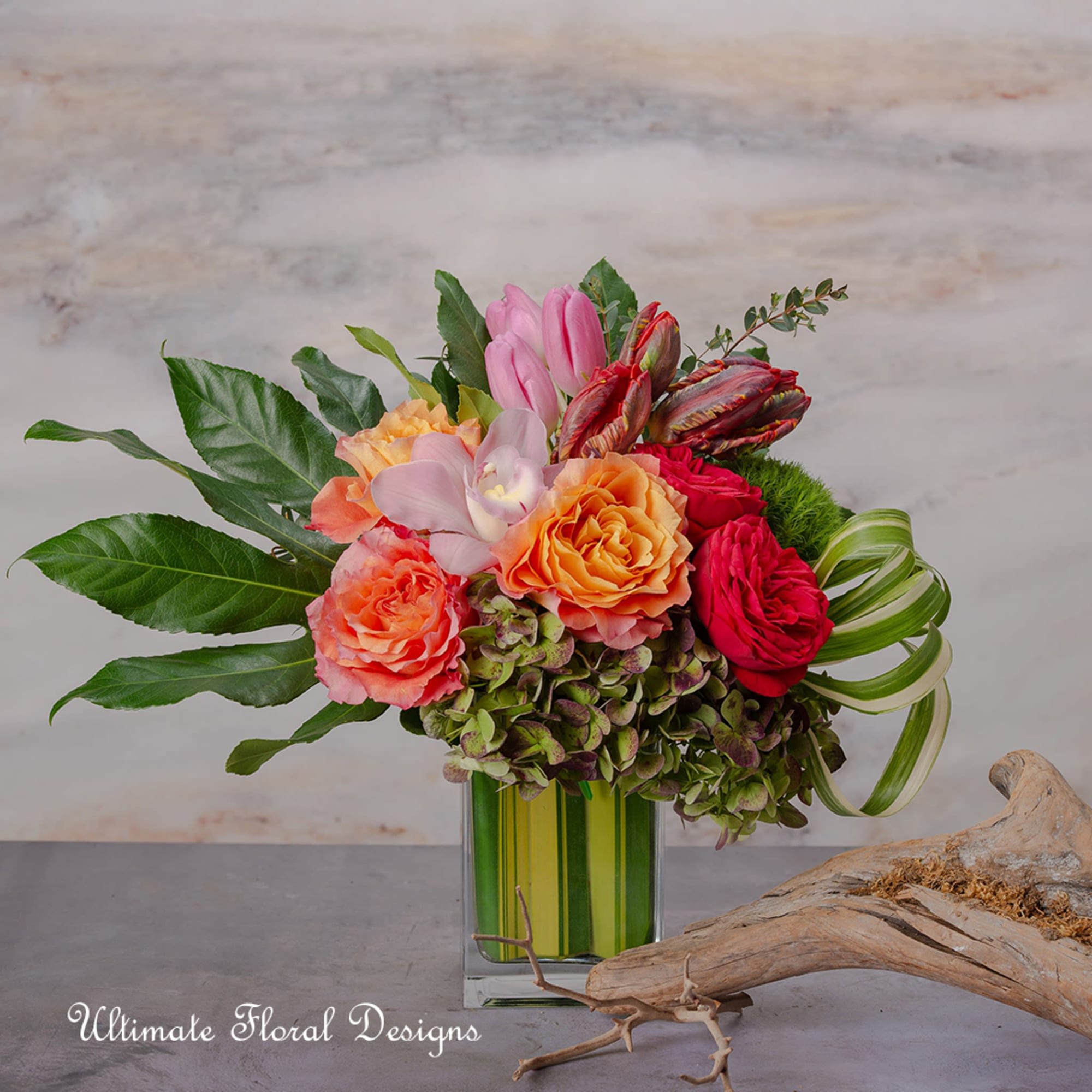 Colorful bouquet of roses, orchids, and hydrangeas in a glass vase