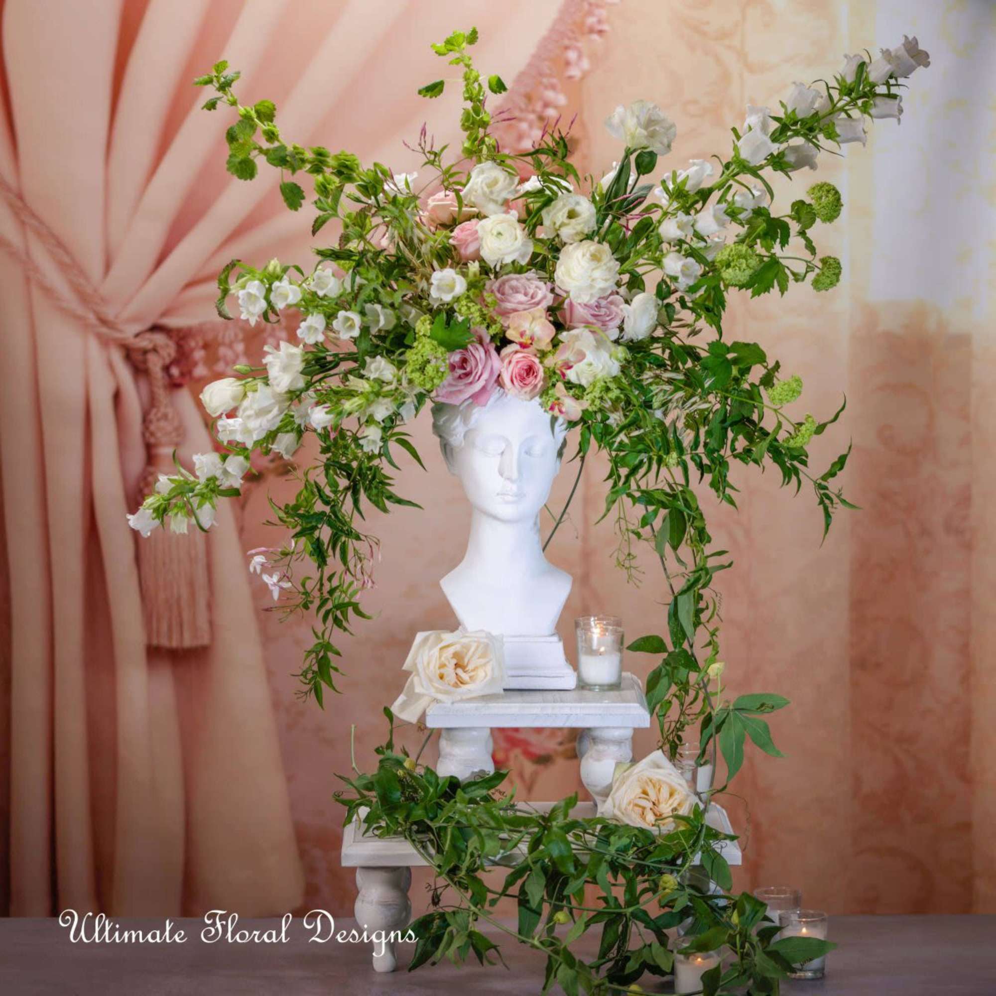Floral arrangement with pink and white roses on a white bust pedestal