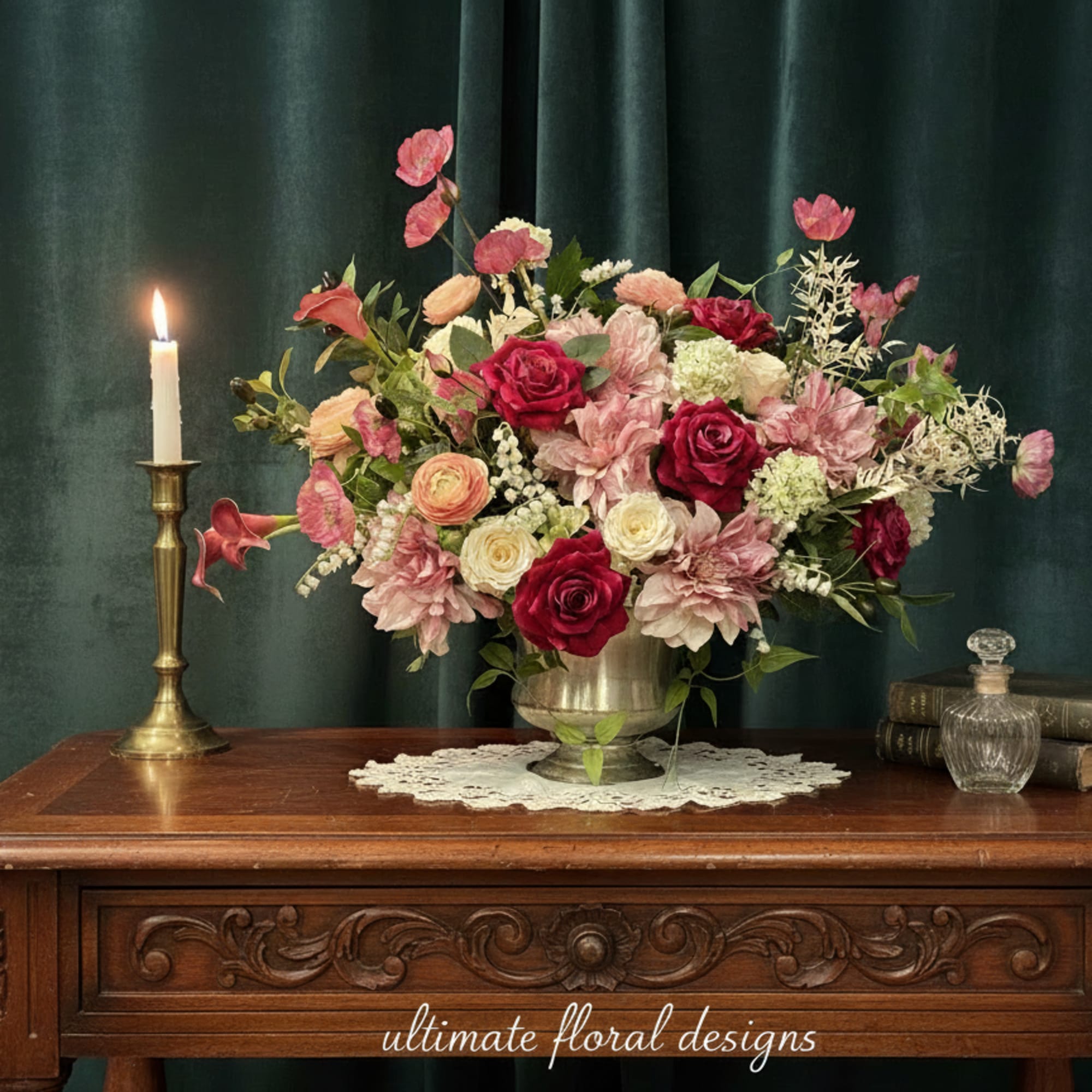 Pink and red floral arrangement in a metal vase beside a lit candle