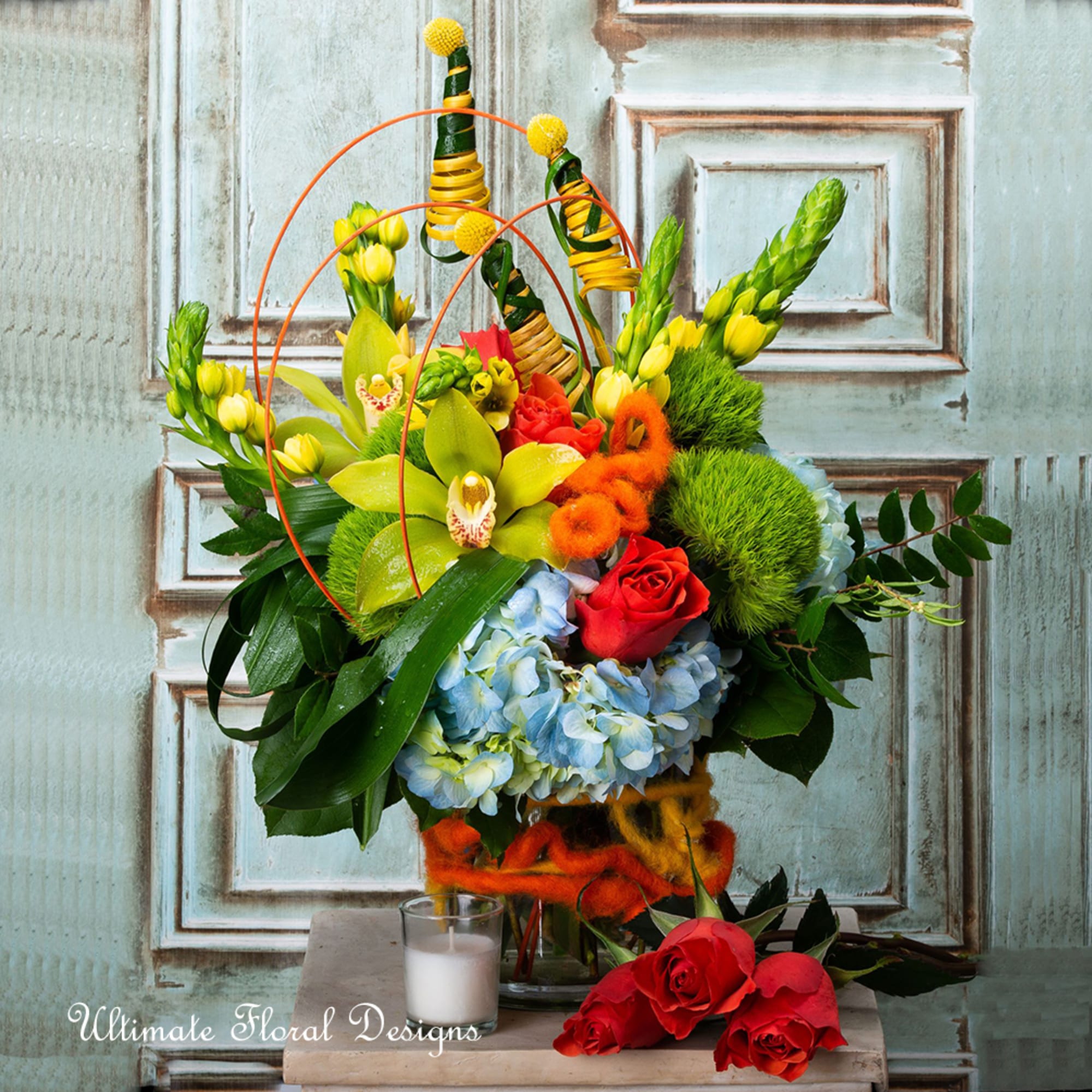 Colorful floral arrangement with roses, orchids, hydrangeas, and decorative loops