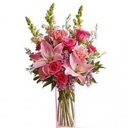 Pink bouquet with lilies and roses in a clear rectangular vase