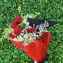 Bouquet of red roses and white flowers with a congratulatory card