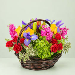 Basket of mixed flowers with roses, lilies, and purple blooms