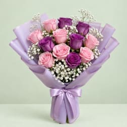 Bouquet of pink and purple roses wrapped in lavender paper